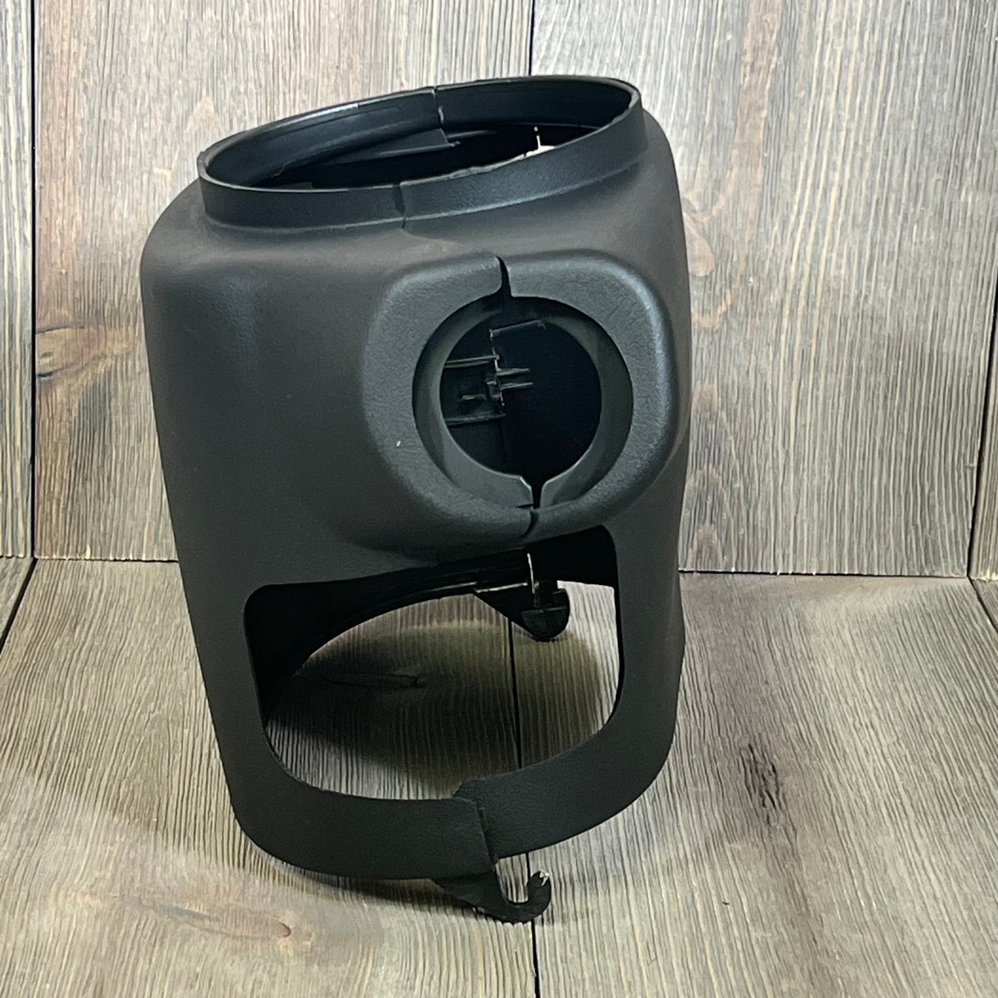 Black LOSTAR steering column cover shroud for 2003-2006 Chevy/GMC, shown on wooden background. Durable and precise fit.