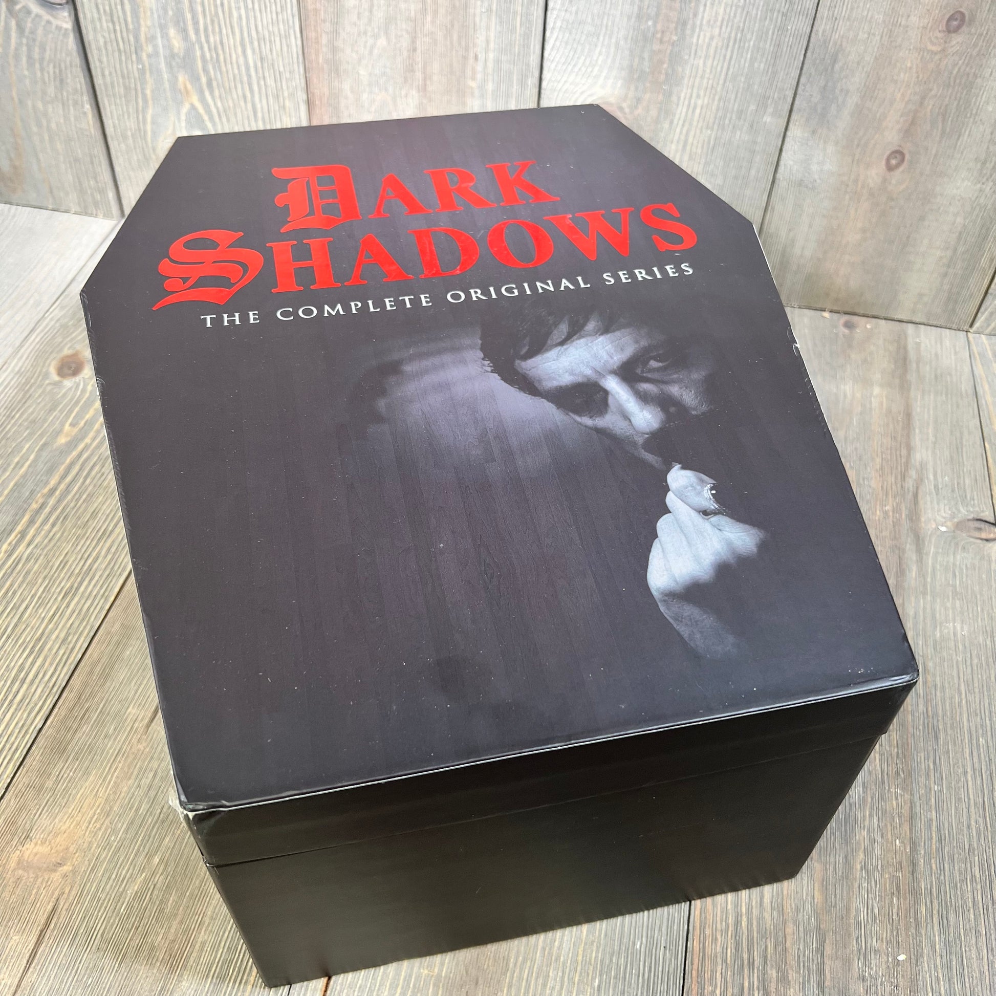 "Dark Shadows: The Complete Original Series" Deluxe Edition DVD set in coffin-shaped box on wooden background.