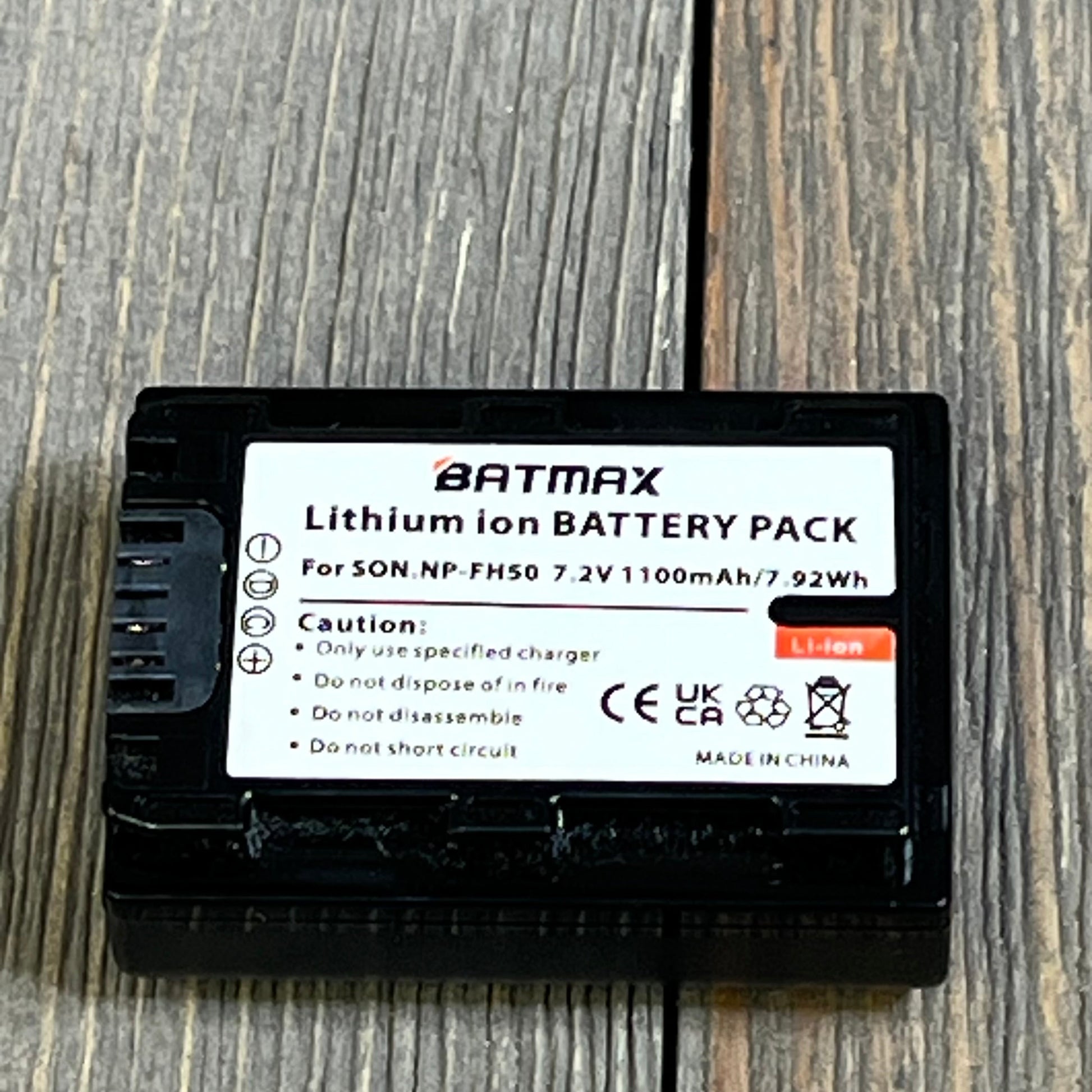 Batmax NP-FH50 lithium-ion battery pack for Sony Alpha DSLR and Cyber-Shot, showing caution label and specifications.