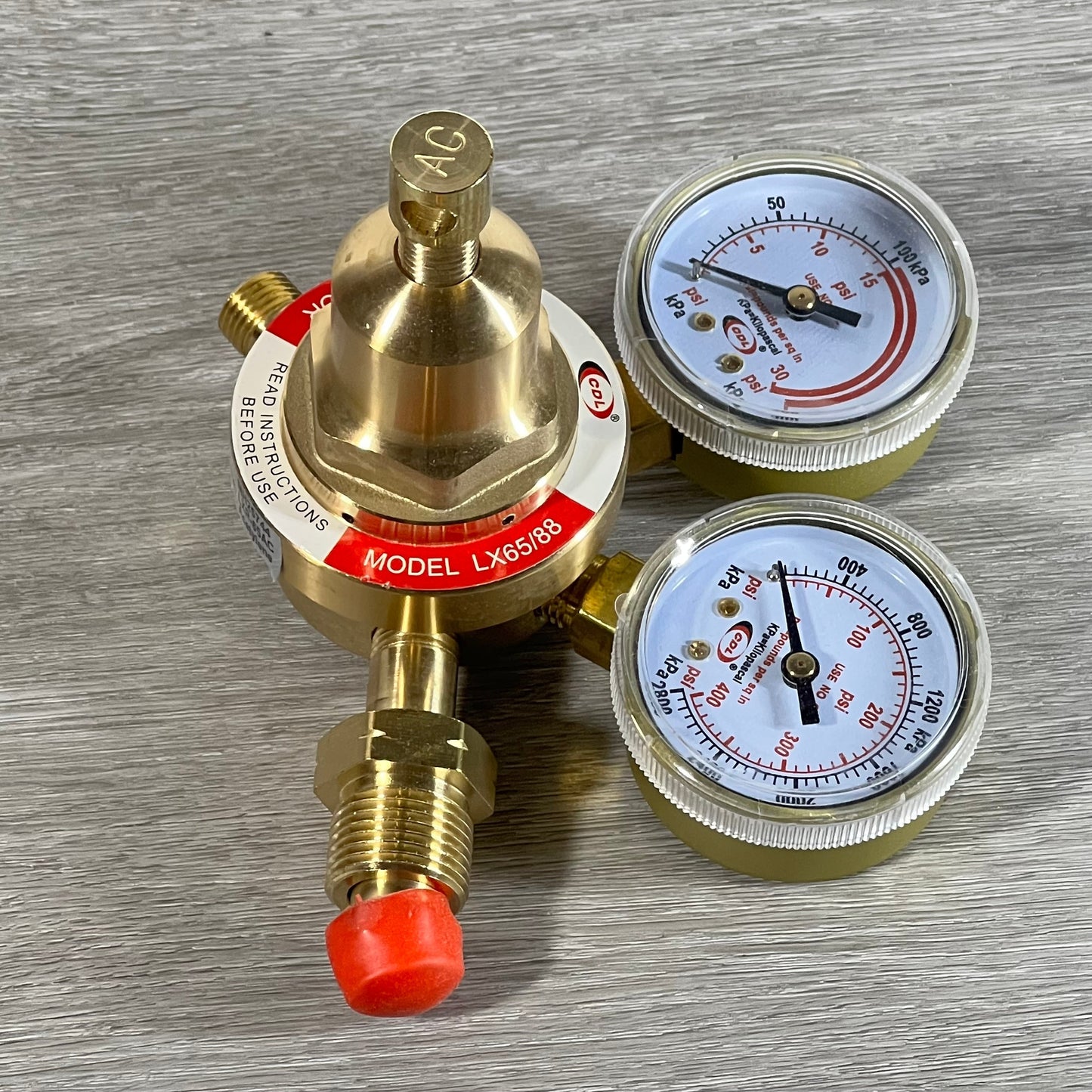 Gold LX65/88 acetylene regulator with dual gauges and CGA510 connection on a wooden surface.