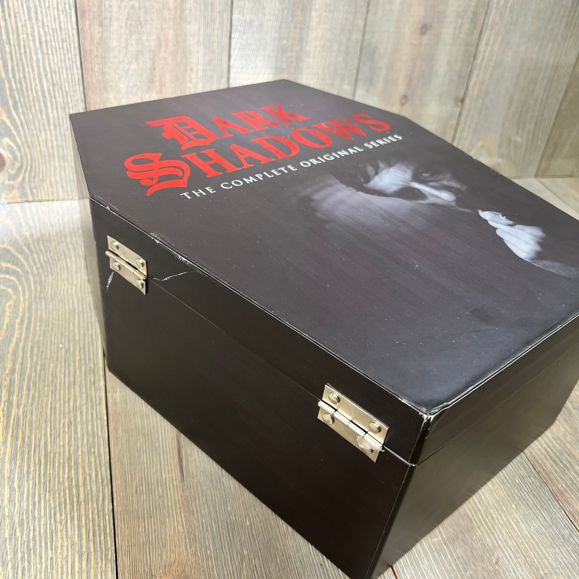 Alt text: "Dark Shadows: The Complete Original Series Deluxe Edition DVD set in a black box with red text on a wooden surface