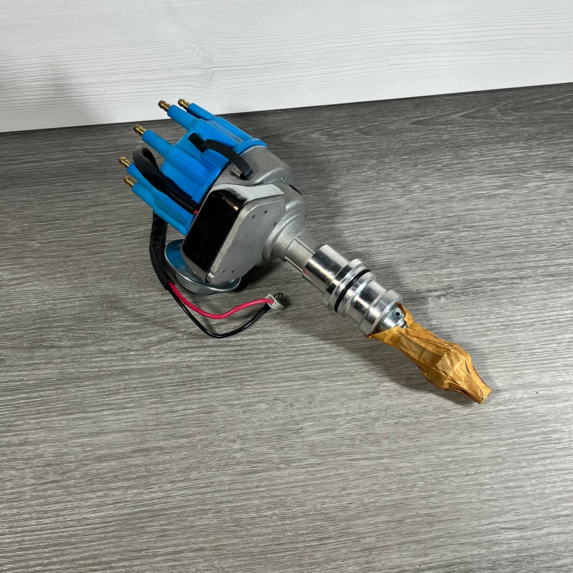 A-Team Performance distributor for Ford SBF 351W, featuring a durable red cap, displayed on a wooden surface.