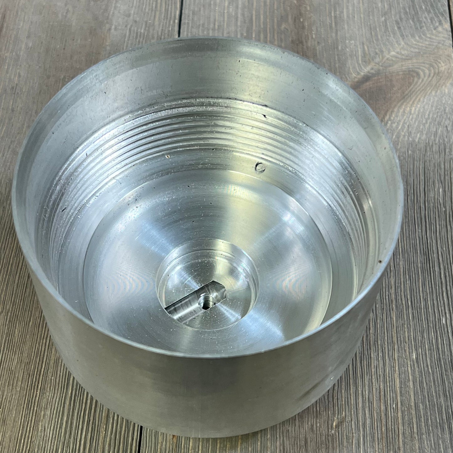 Aluminum fuel filter housing for 2011-2016 F-250 F-350 F-450 with 6.7L Powerstroke Diesel, top view on wooden surface.
