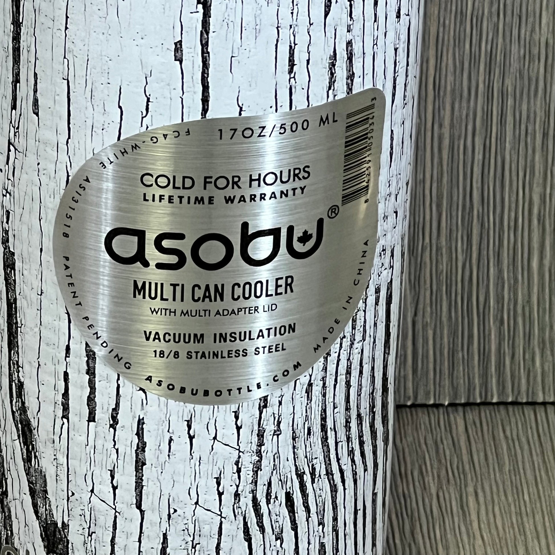 White Asobu Multi Can Cooler with wood grain texture, vacuum insulated for 12 oz and 16 oz drinks, and stainless steel label.