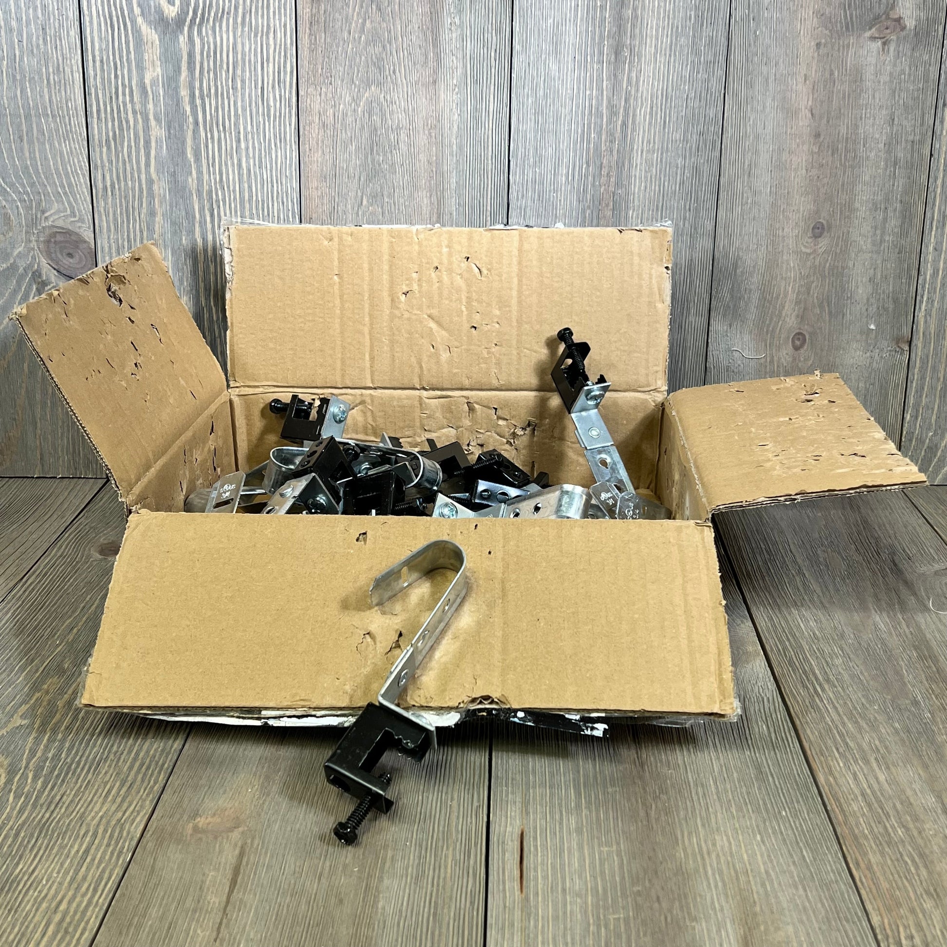 Open box of Blulu J Hooks with swivel beam clamps, ideal for cable management and organizing wires, G60 galvanized steel.
