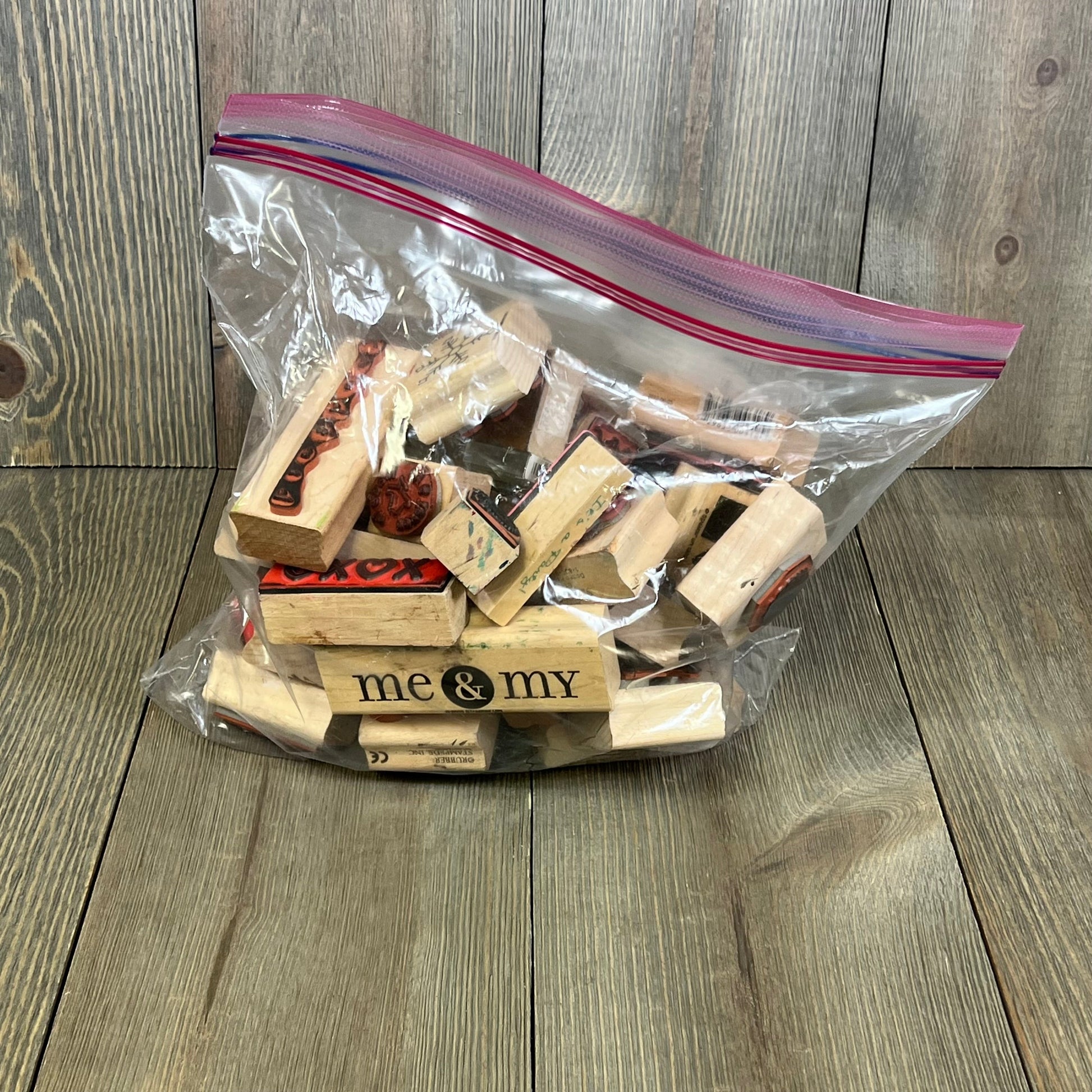 Clear bag filled with 33 assorted wooden ink stamps, ideal for crafting and scrapbooking.