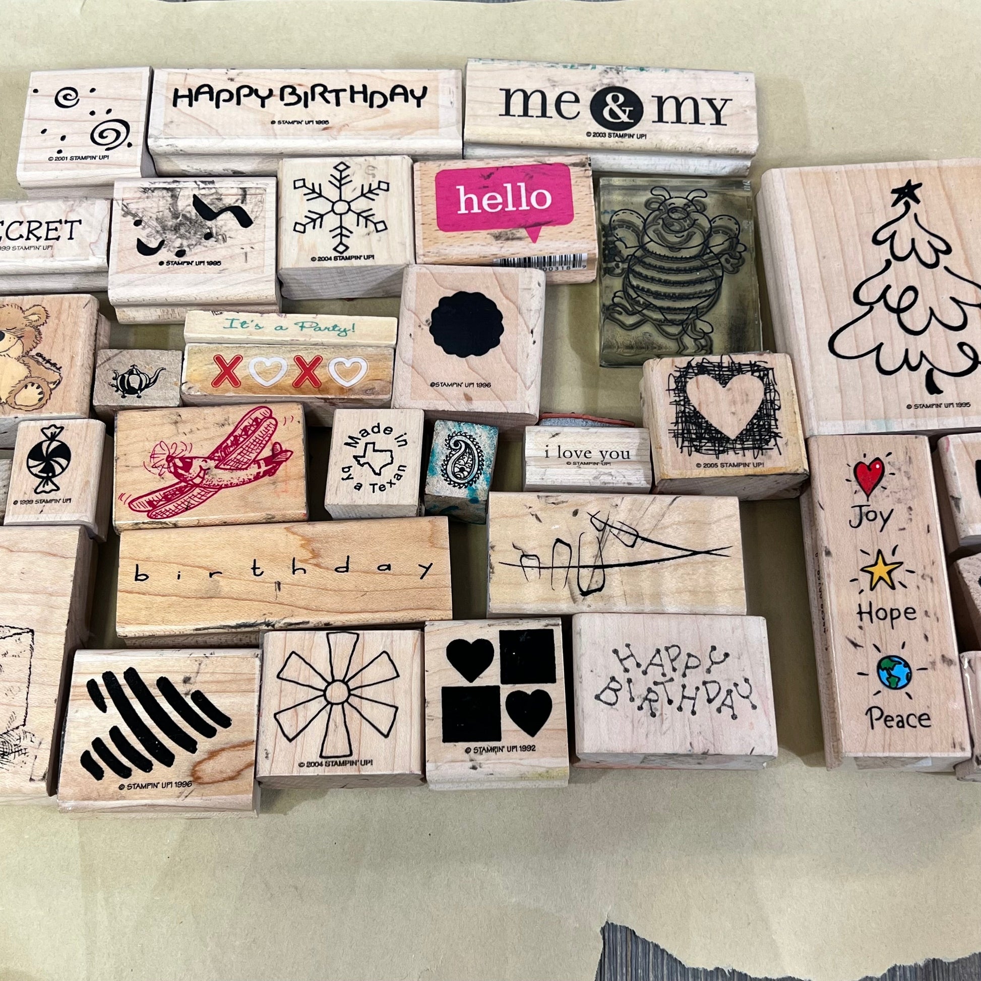 Diverse collection of 33 wooden ink stamps featuring unique designs and messages for creative crafting projects.