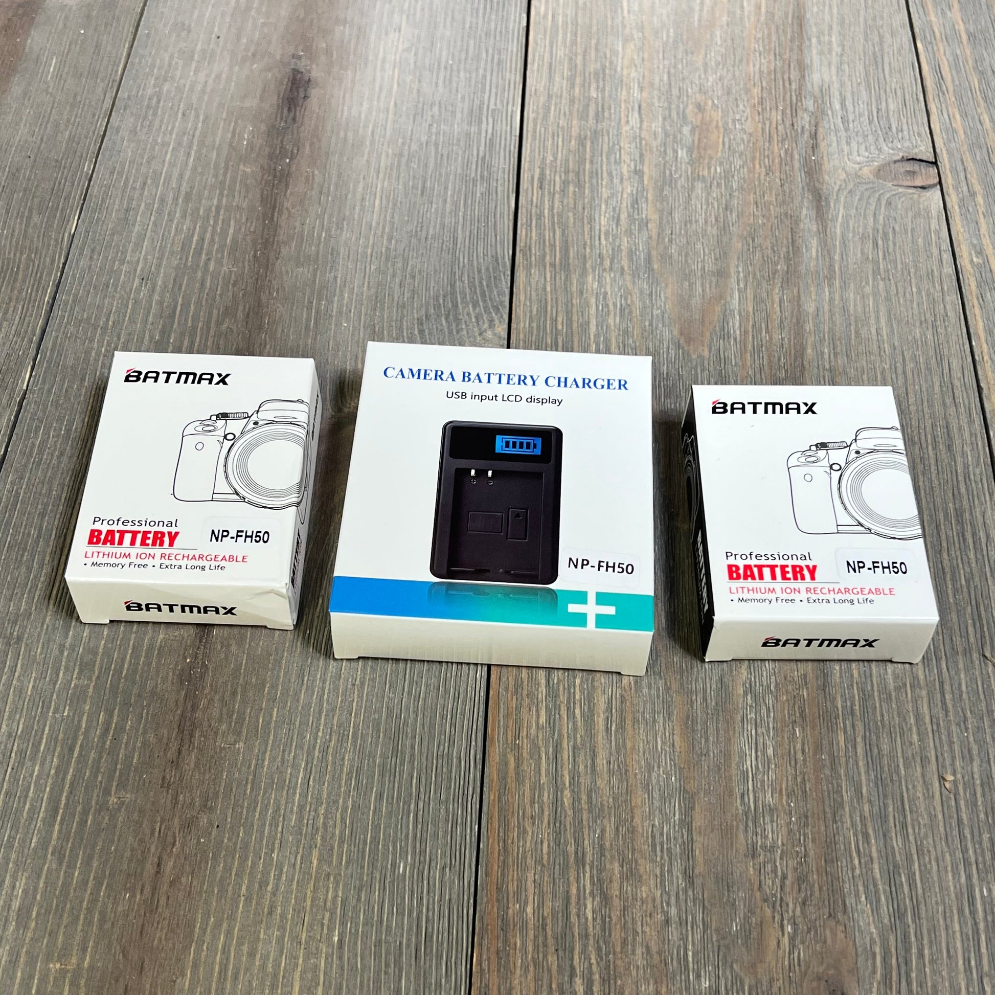 Batmax NP-FH50 battery and LCD USB charger set for Sony cameras on wooden background.