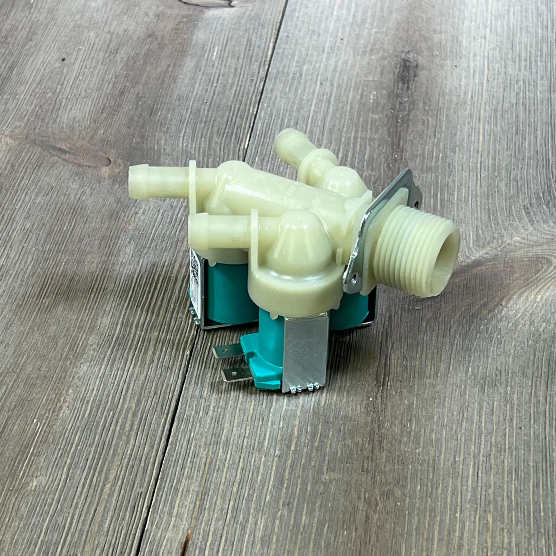 Water inlet valve for LG, Kenmore washers, model 1045811647-5220FR2075L, shown with dual connectors on wooden surface.