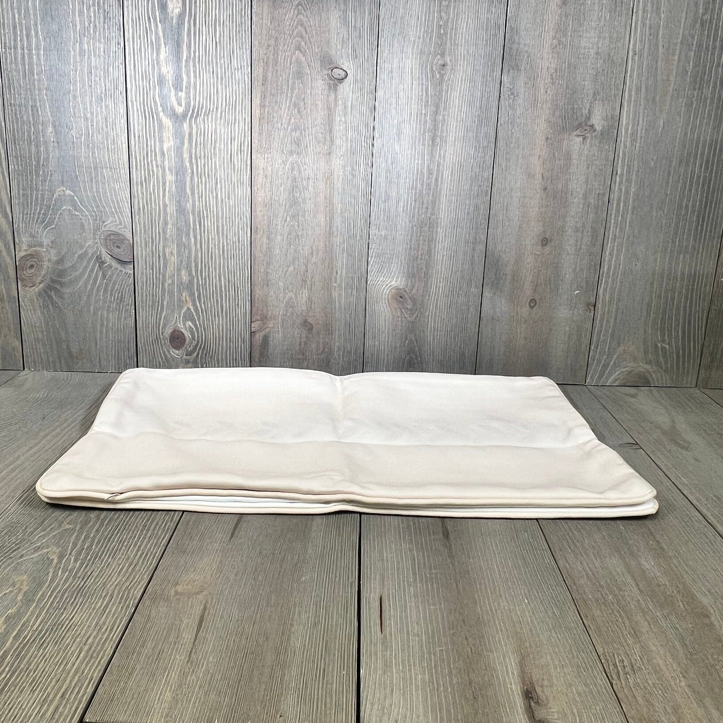 Neutral tan lumbar pillow cover with embroidered leaf design and piping, perfect for coastal patio or indoor use.