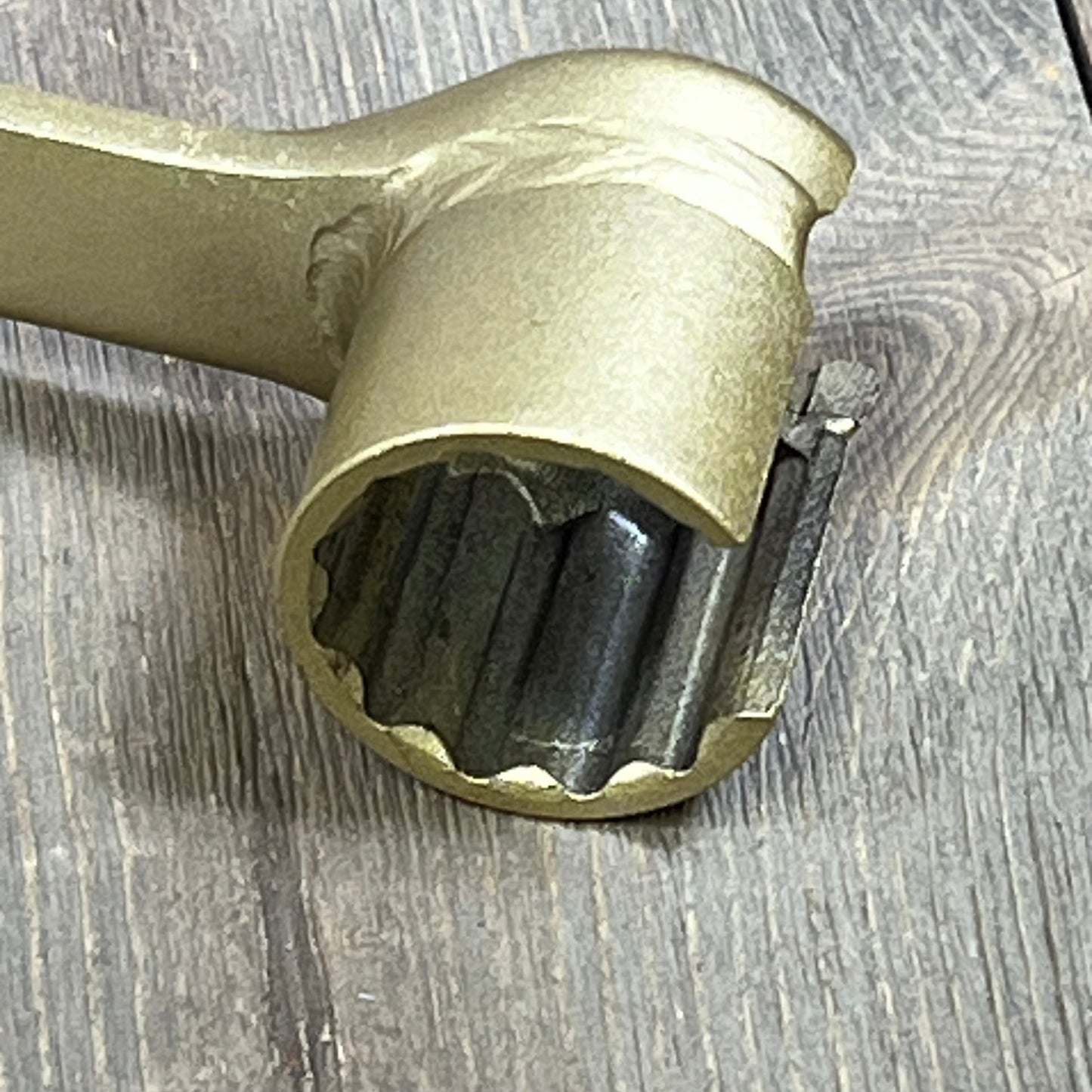 Gold-toned ANTUKO IPR Valve Injector Pressure Regulator Removal Tool with detailed gear design on wooden surface.