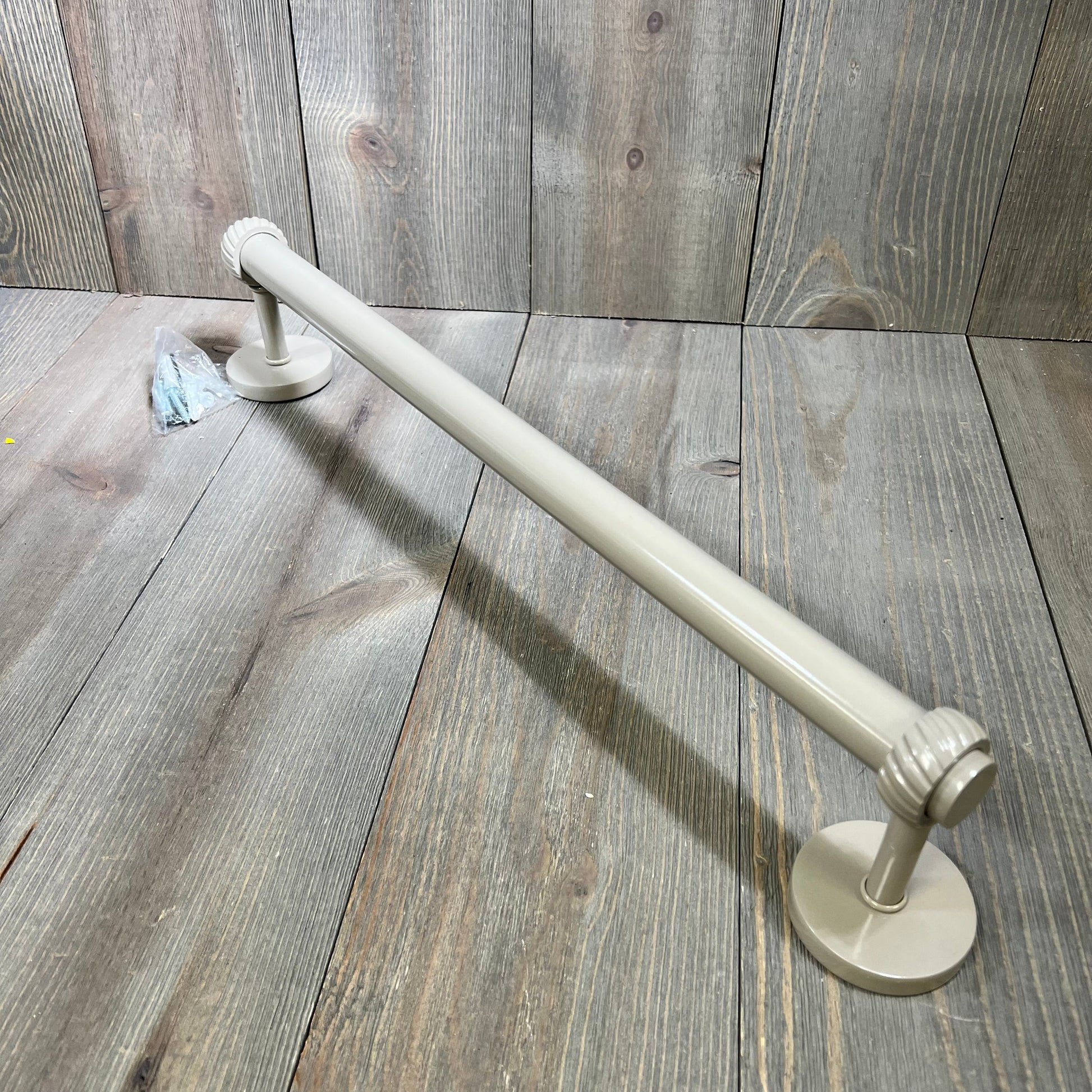 Shaded beige 18-inch towel bar with twist detail from Allied Brass Satellite Orbit Two Collection on wood background.