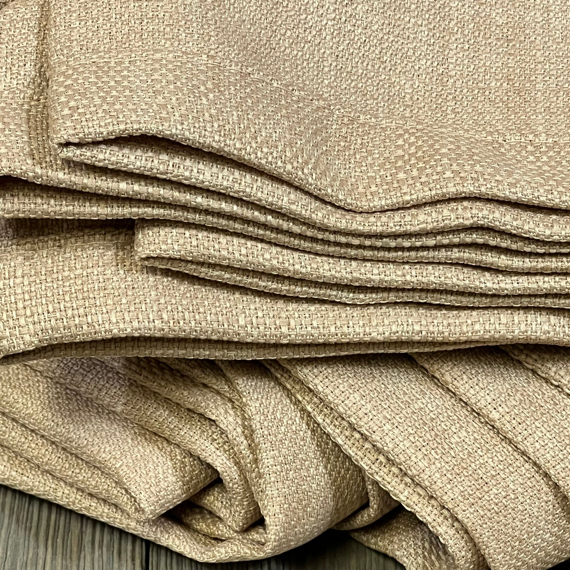 Burlap textured tan faux linen curtains folded, showcasing thick light-filtering fabric for living room privacy.