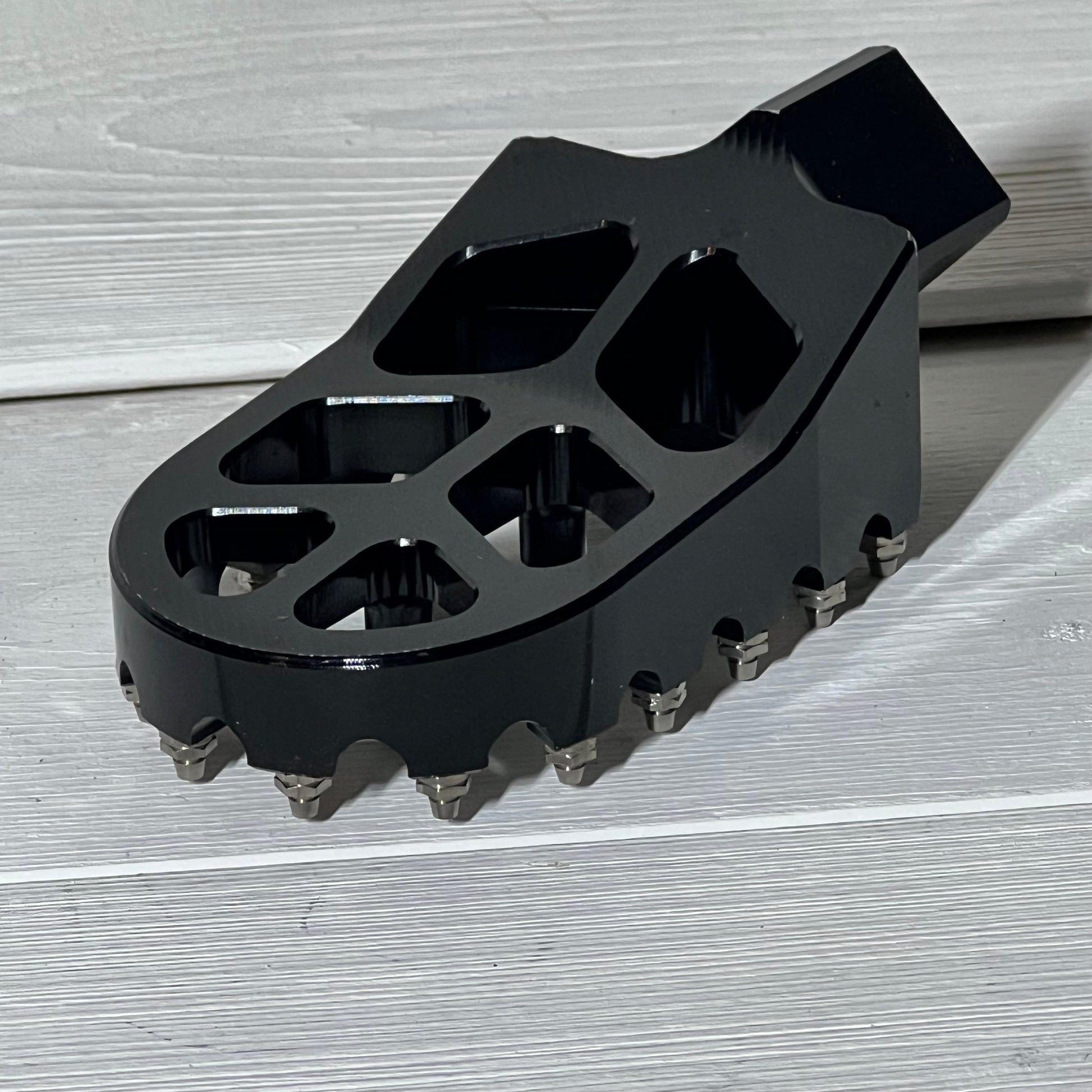Black AnXin motorcycle foot peg for PW50, PW80, and pit dirt bikes, featuring a rugged design for enhanced grip and stability.