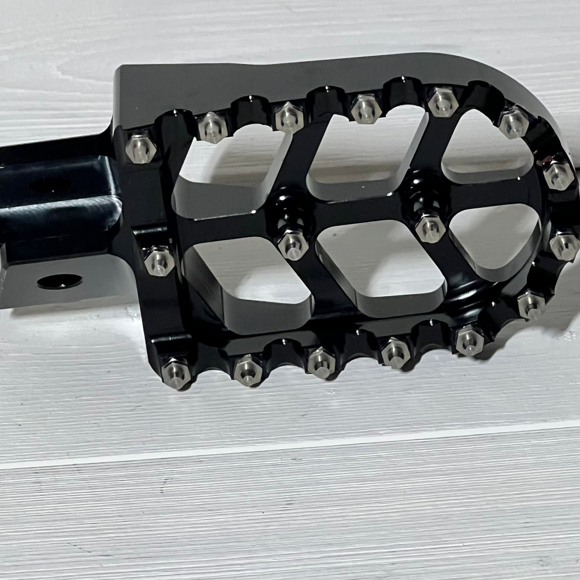 Black AnXin motorcycle foot peg for PW50 and PW80, featuring durable metal construction and grip-enhancing design.