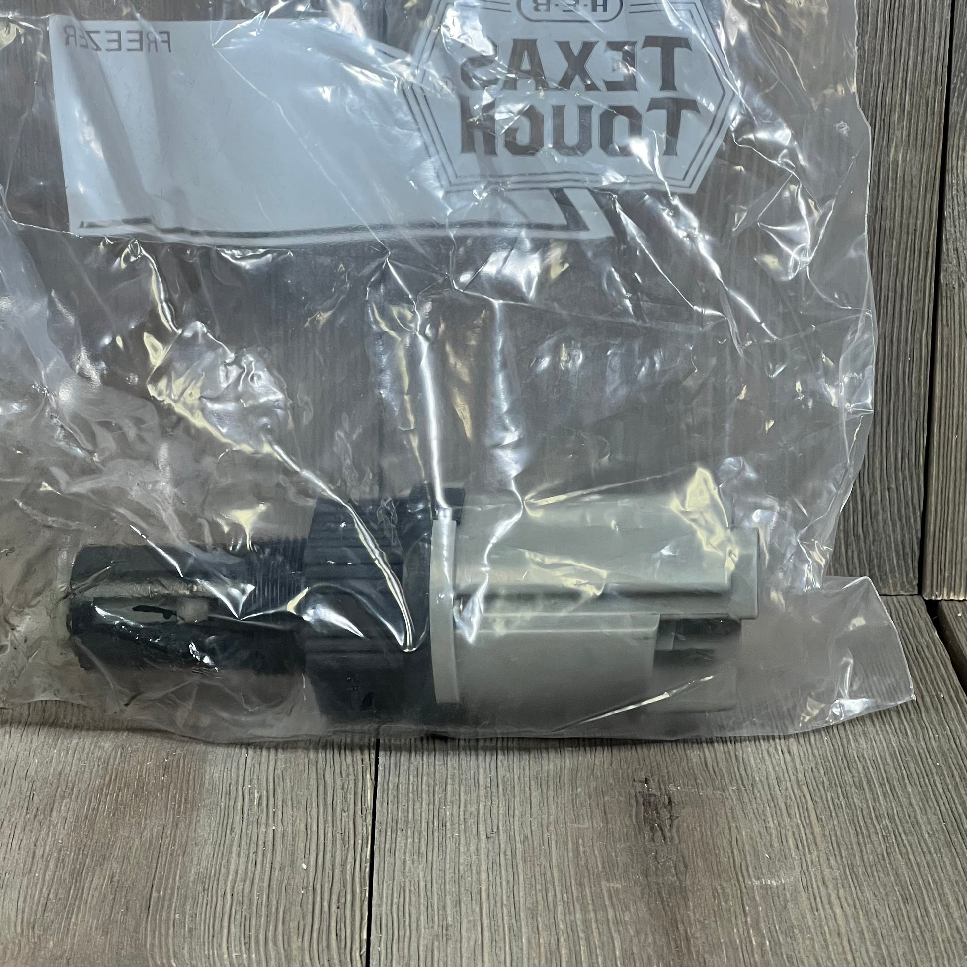 4WD front differential axle actuator replacement for Silverado, Suburban, Sierra in protective packaging on wooden surface.