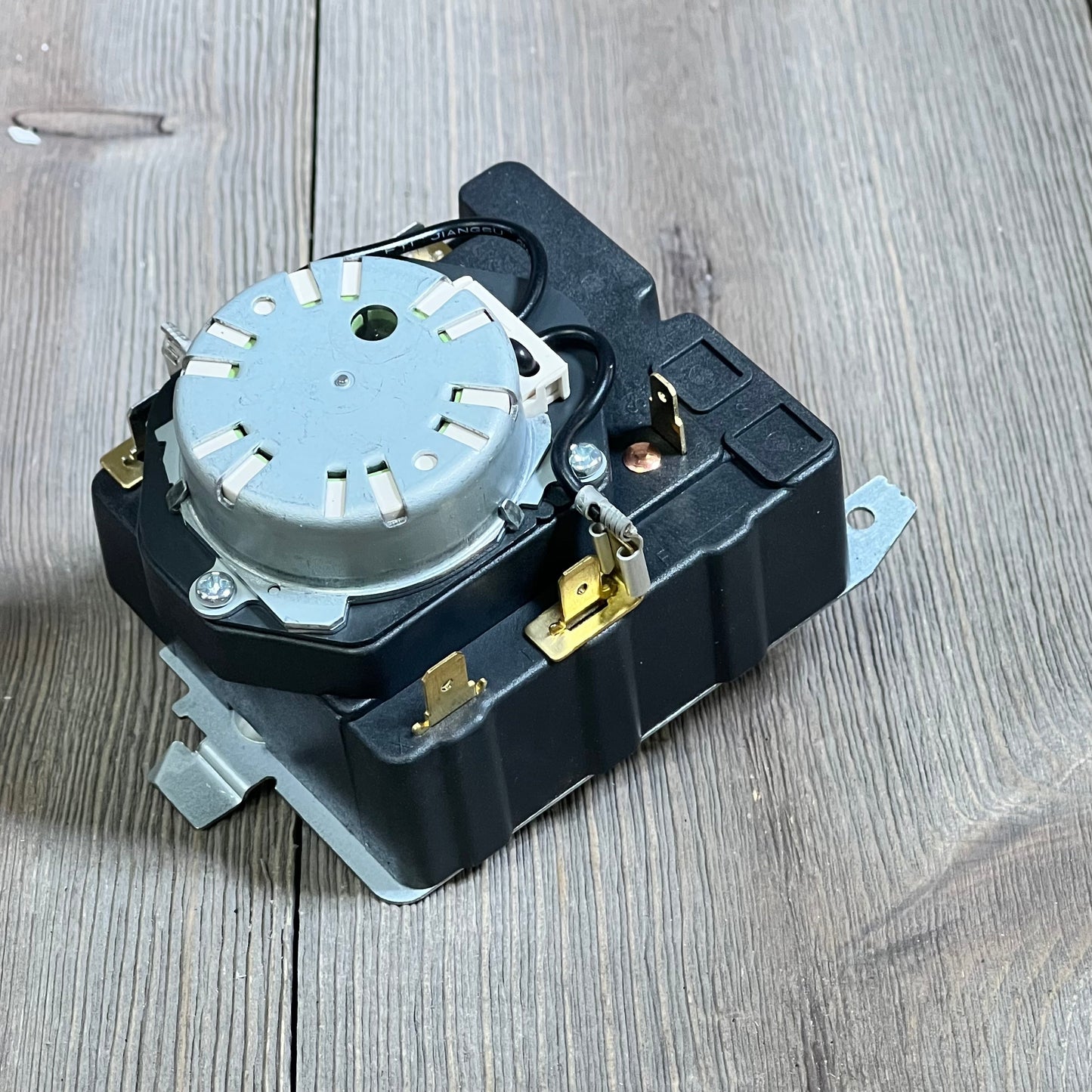 OEM dryer timer replacement for GE models shown on a wooden surface, featuring durable design for enhanced performance.