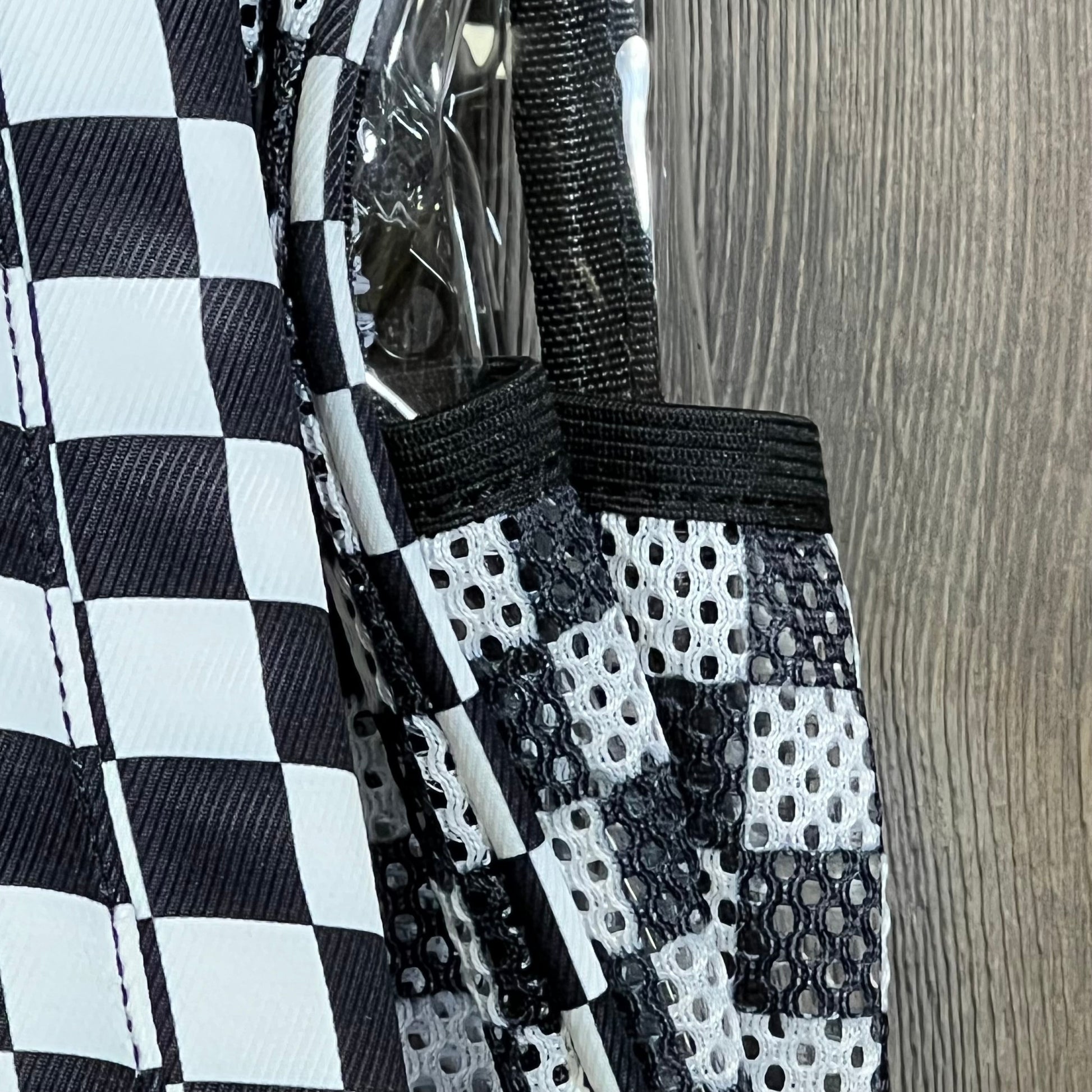 Clear mini backpack with checkered pattern detailing, ideal for stadium events and concerts. Transparent and stylish design.