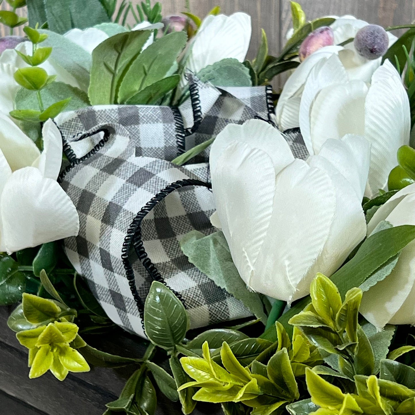Artificial white tulips with greenery and checkered ribbon in a wood box, perfect for spring table decor.