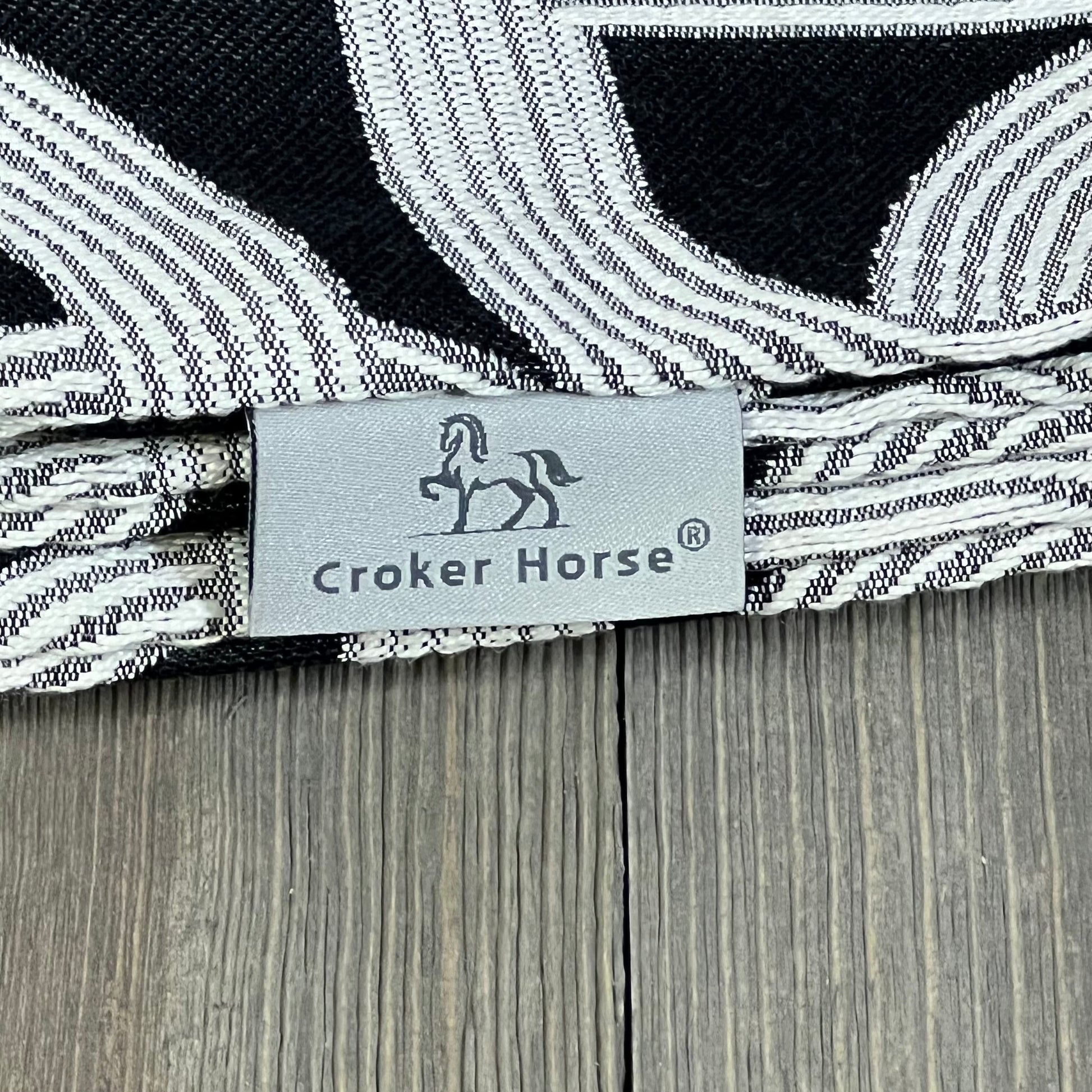 Croker Horse luxury pillow cover with black embroidery, featuring a detailed horse and horseshoe pattern on a modern design.