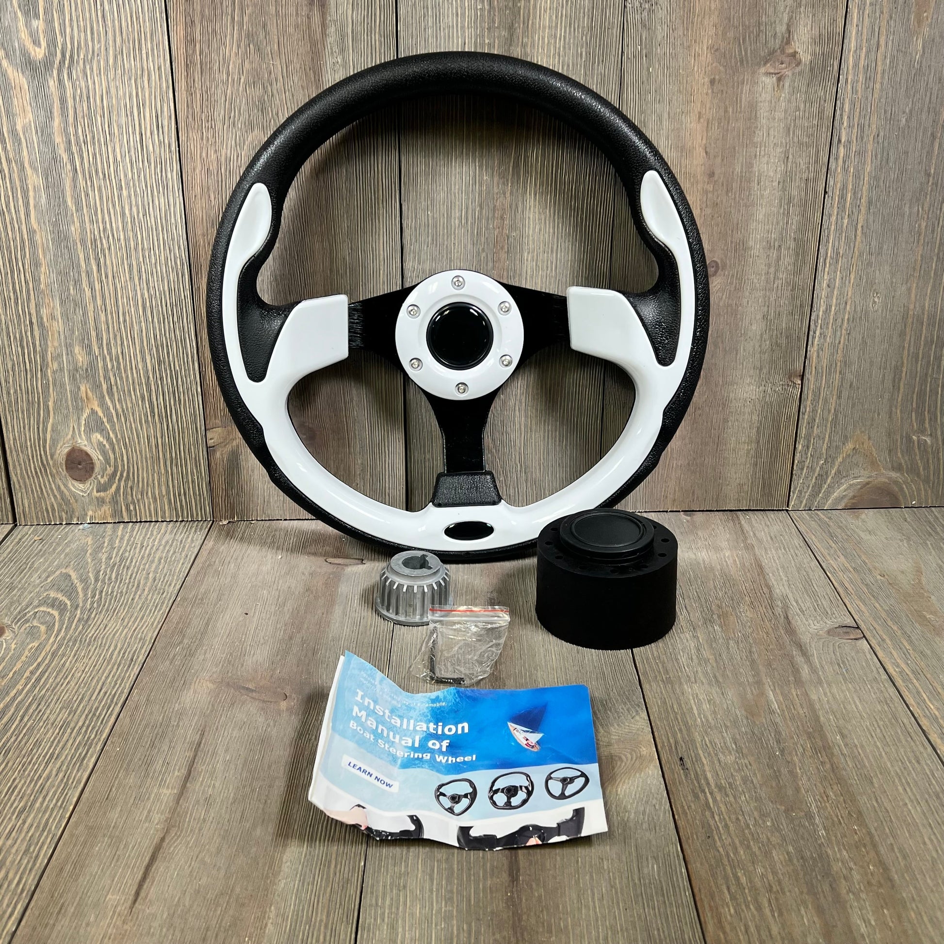 12.5-inch boat steering wheel with adapter, anti-slip grip, shown with installation manual and components on wooden surface.