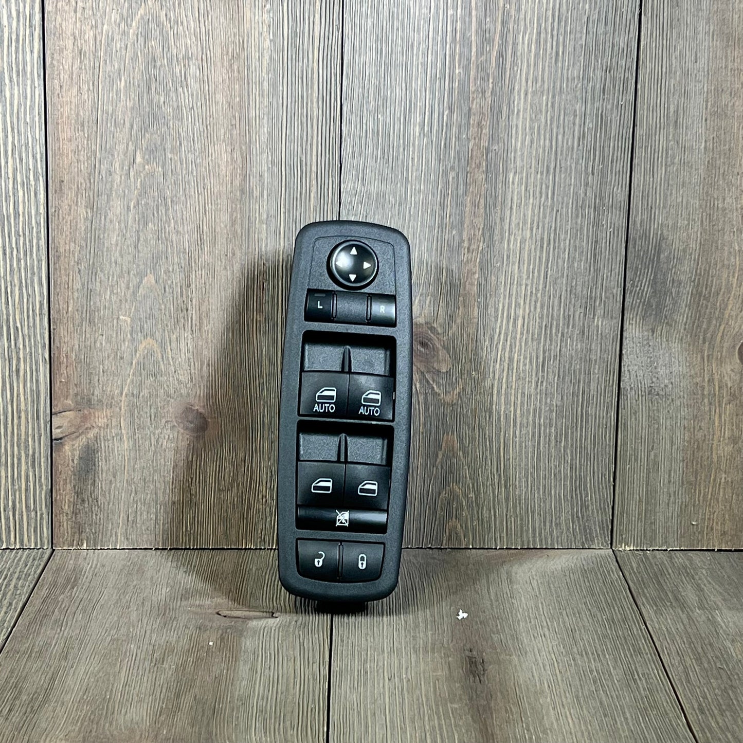 Master Power Window Switch for Chrysler 300, 200, Dodge Charger, Ram 1500-3500 on wood background.