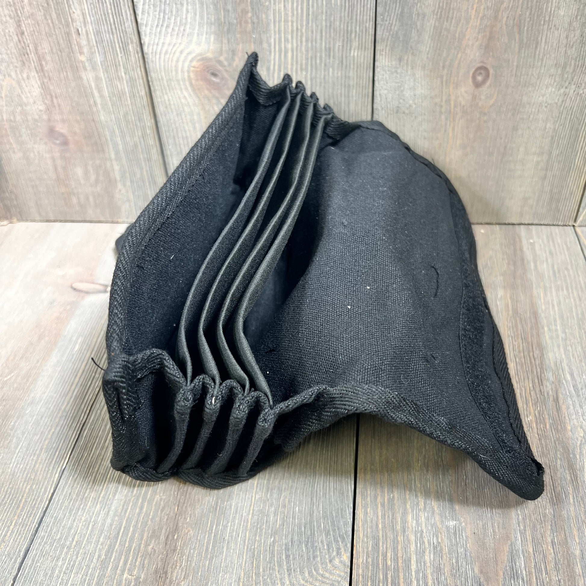 Black Cunno fanny pack with multiple compartments for coins and banknotes on a wooden surface.