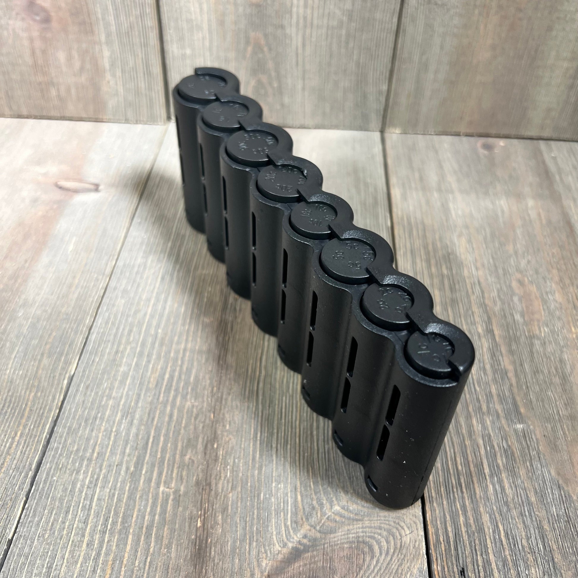 Black euro coin holder with multiple slots for efficient coin sorting and organizing on a wooden surface.