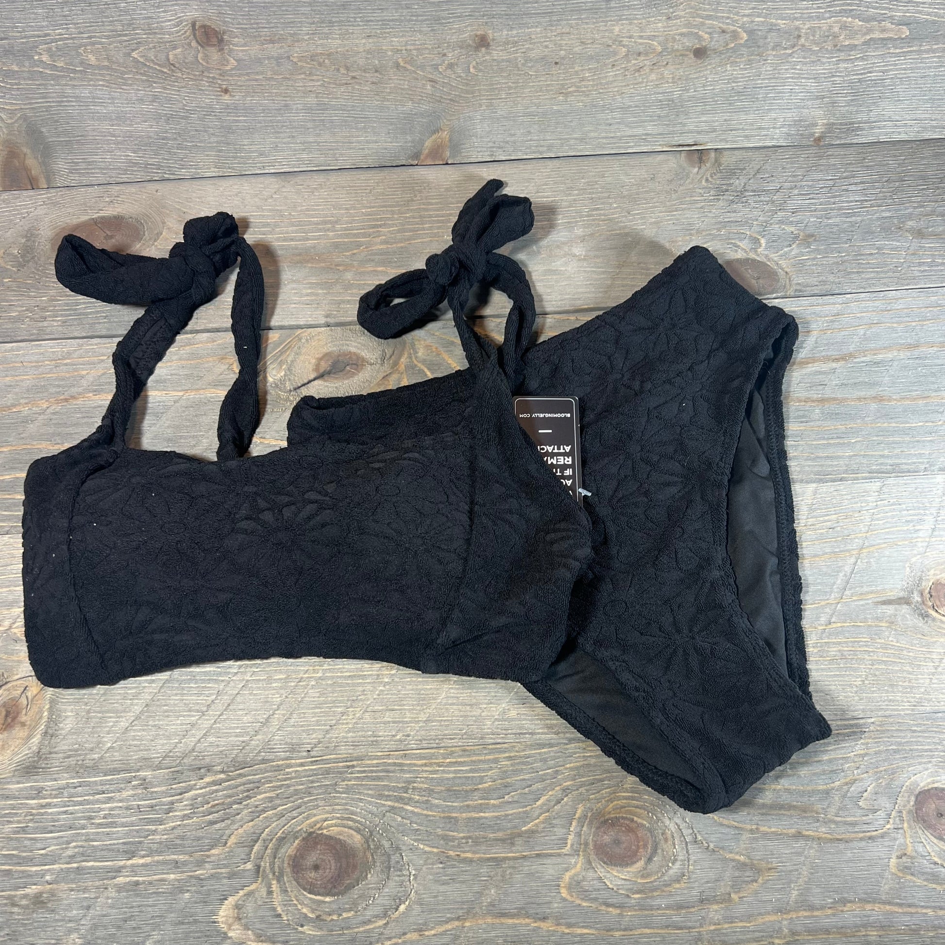 Black high waisted bikini set with floral texture, featuring adjustable straps, size small on wooden background.
