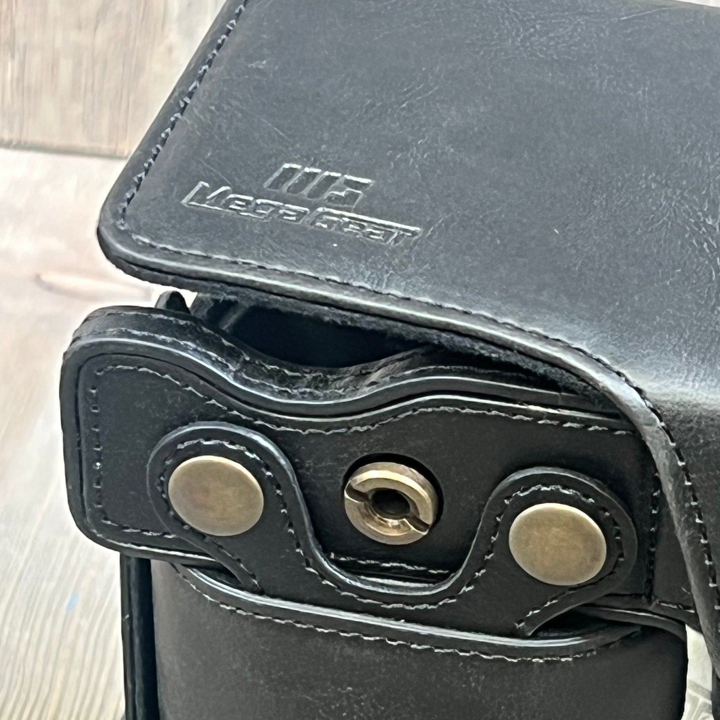 Close-up of MegaGear MG1942 black leather camera case, showing stitching and metal hardware, compatible with Nikon Z5.