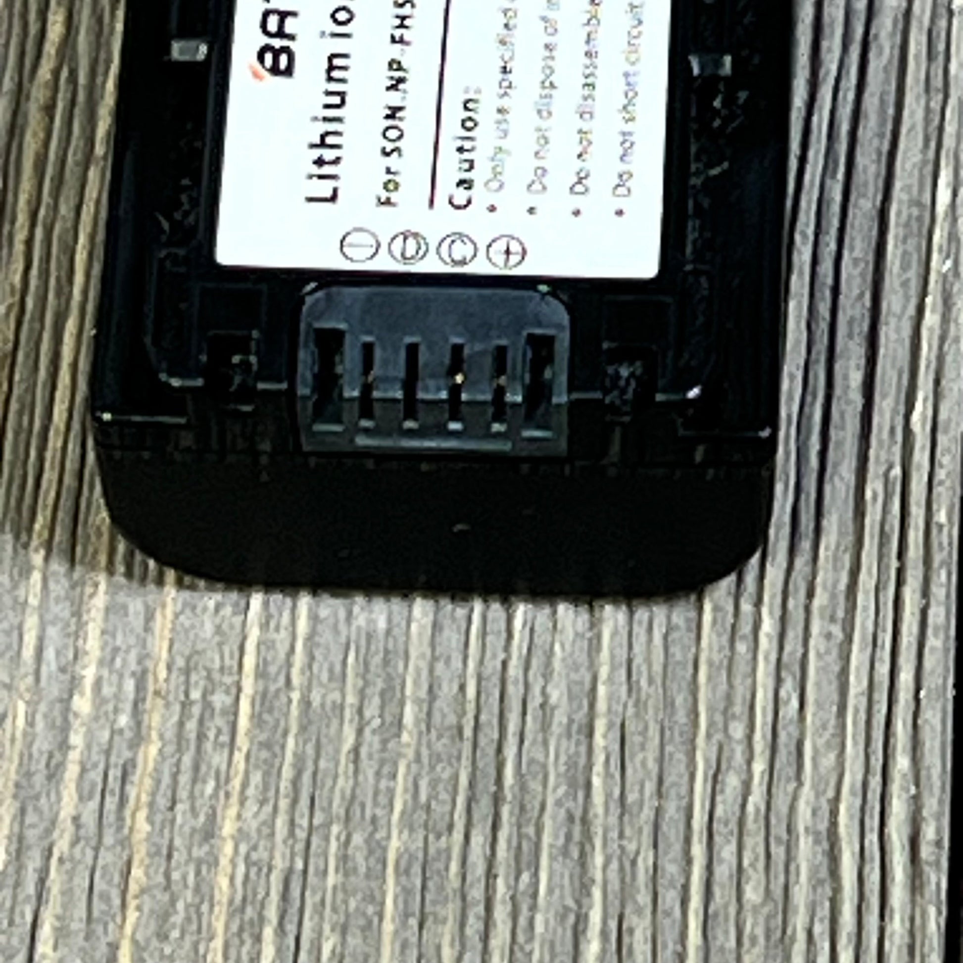 Close-up view of Batmax NP-FH50 battery showing connector pins, compatible with Sony Alpha DSLR and Cyber-Shot cameras.