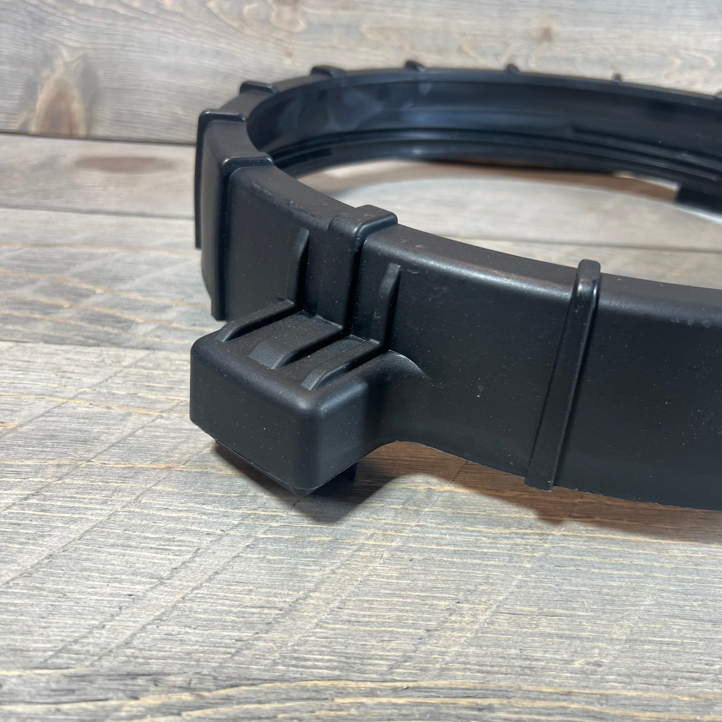 Black locking ring assembly for Pentair Clean & Clear Predator filter, detailed view on rustic wood background.