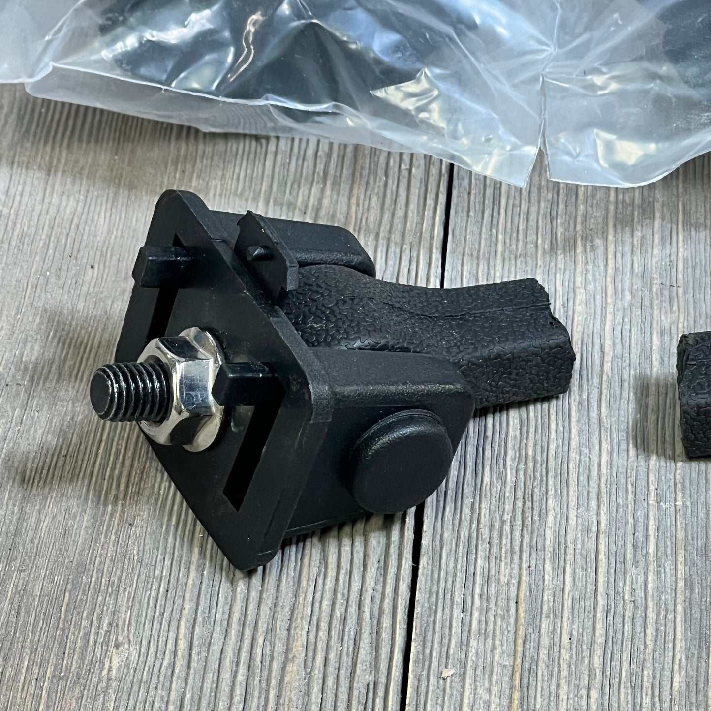 Black Jeep TJ hood latch with textured grip, factory style catch kit part for 1997-2006 Wrangler on wood surface.
