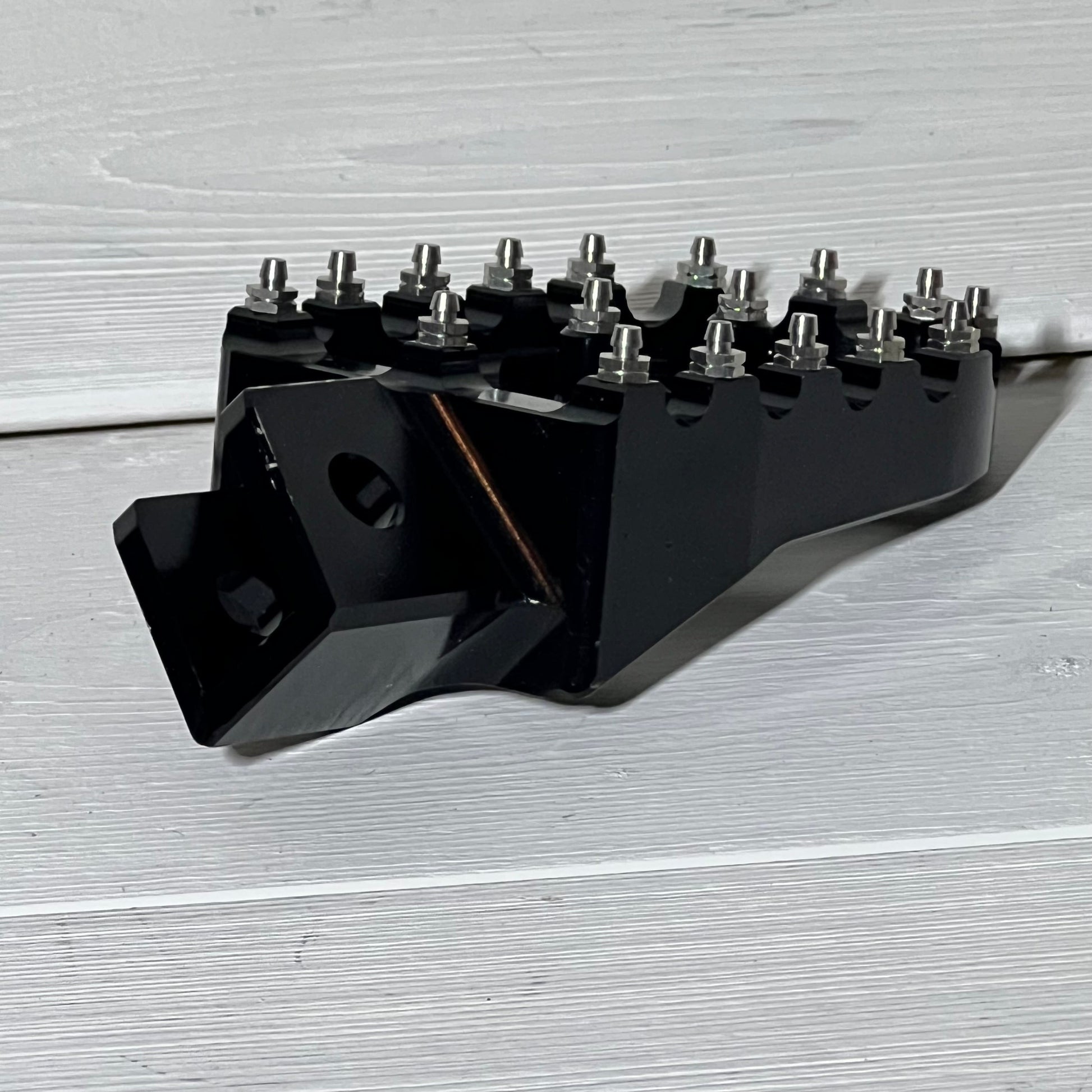Black AnXin motorcycle foot peg for PW50 and PW80, featuring rugged metal spikes for enhanced grip and stability.