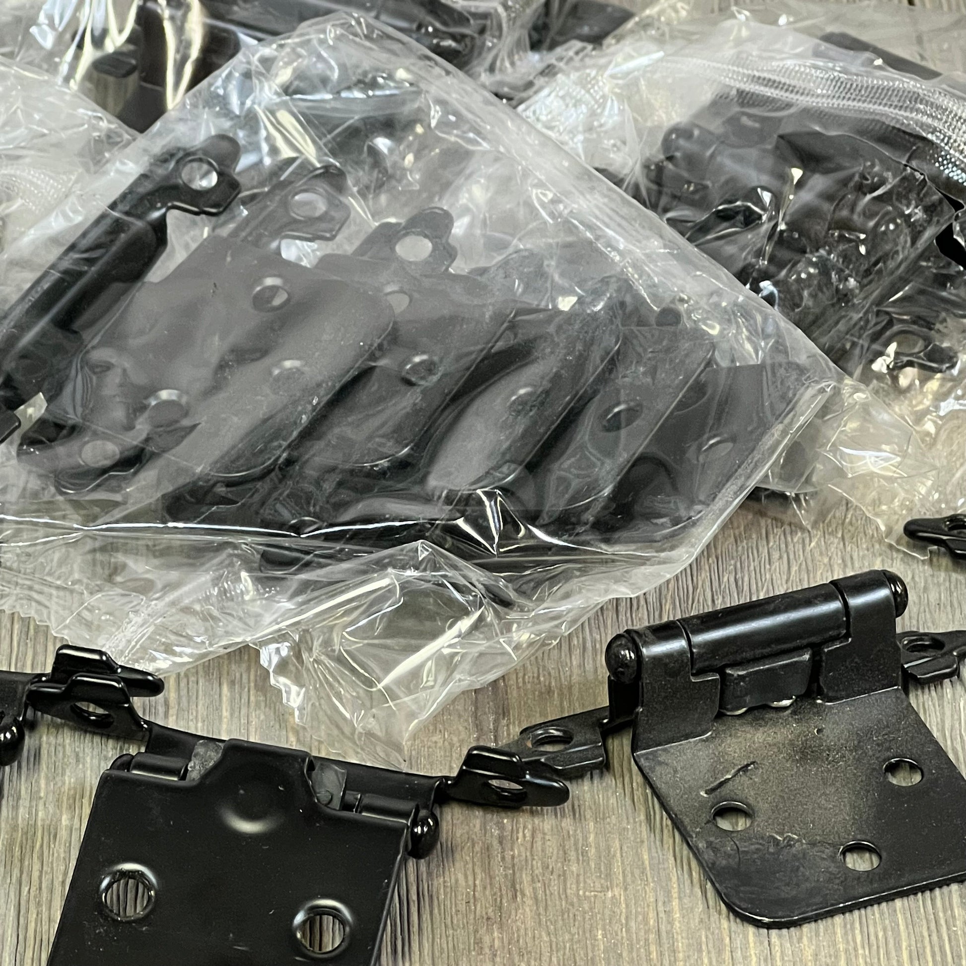 Black 1/2 inch overlay cabinet door hinges in packaging, featuring self-closing mechanism, ideal for kitchen cupboards.