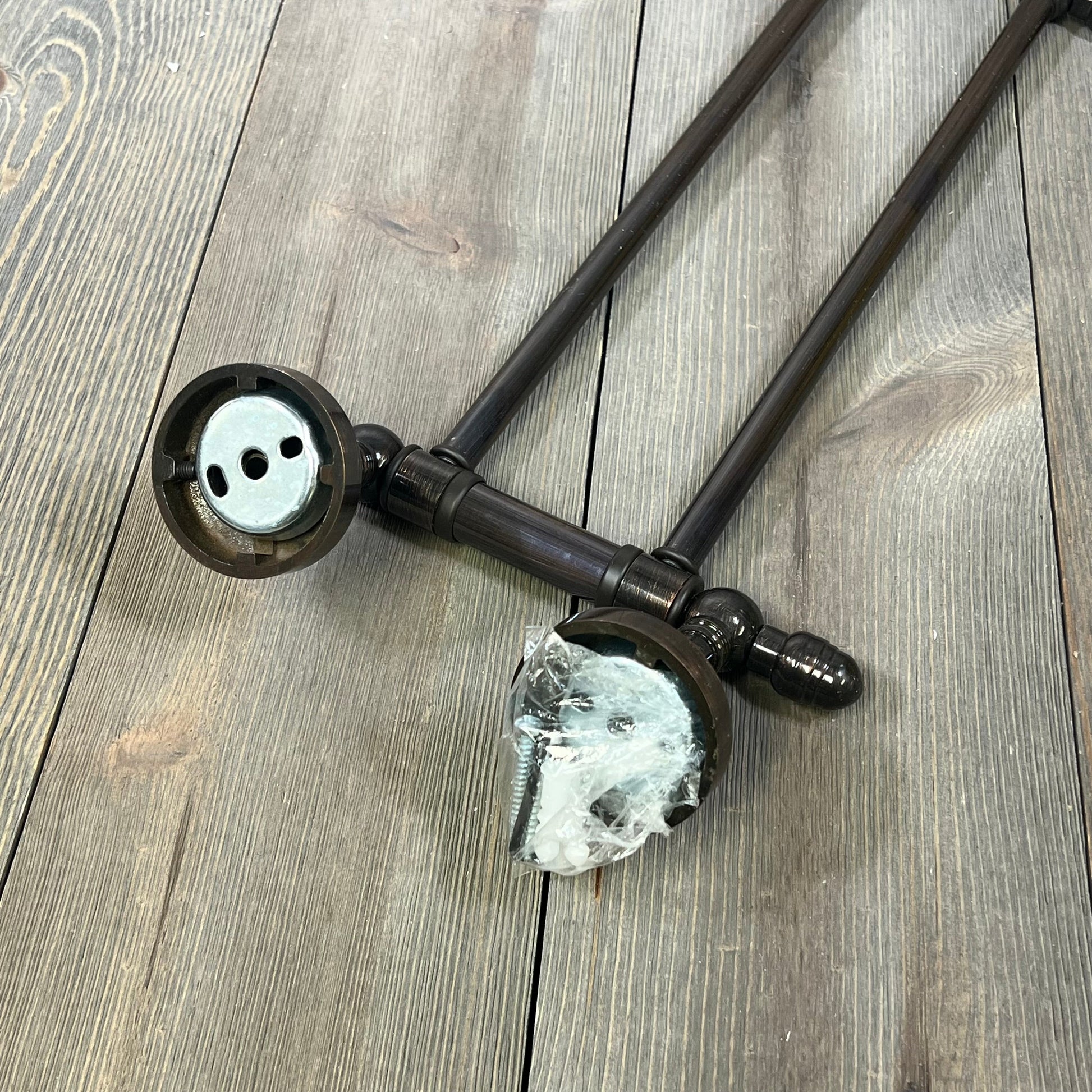 Antique copper swing arm towel rail from Allied Brass Waverly Place Collection on wooden surface.