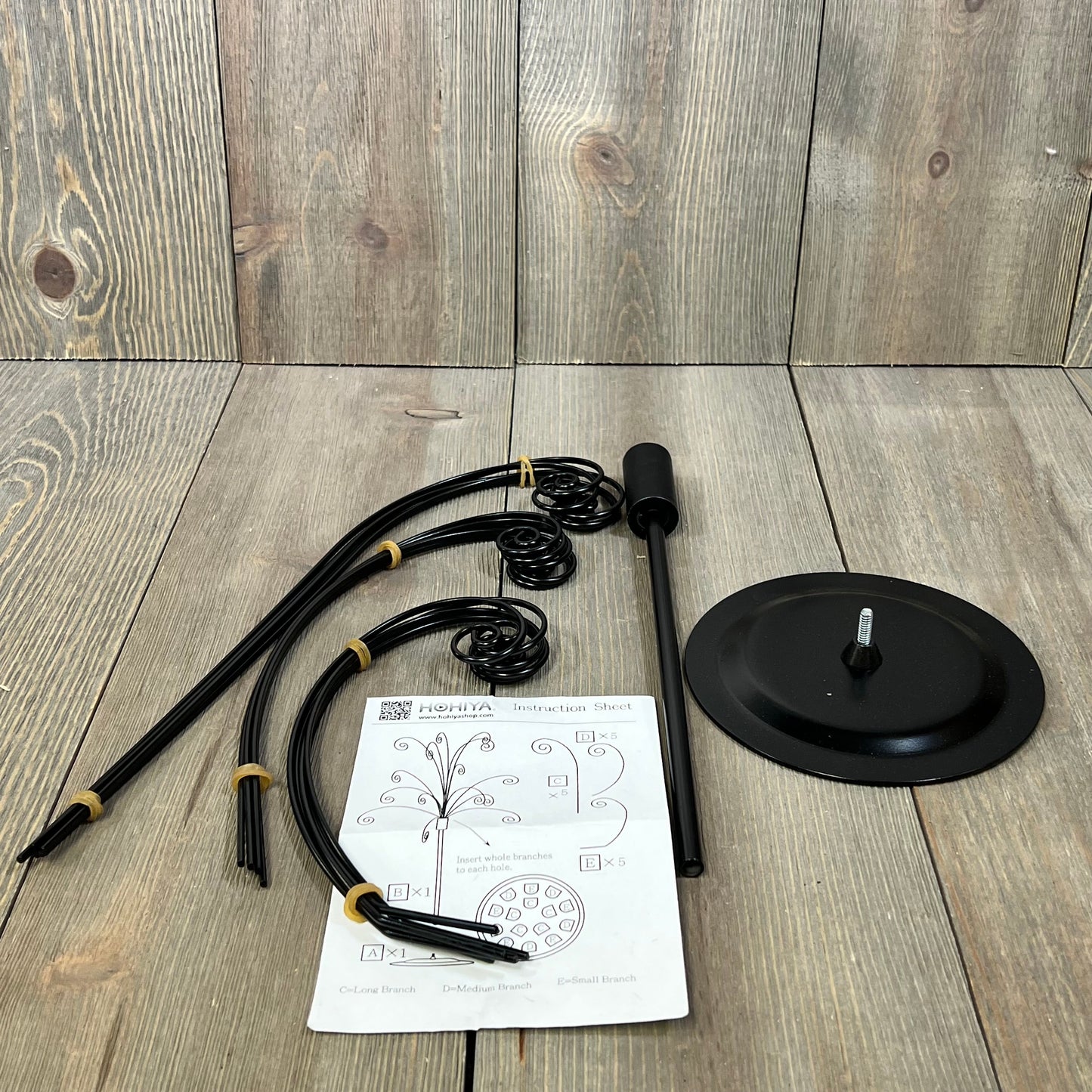 HOHIYA Ornament Tree Display Stand parts and instruction sheet on a wooden background, showcasing assembly components.