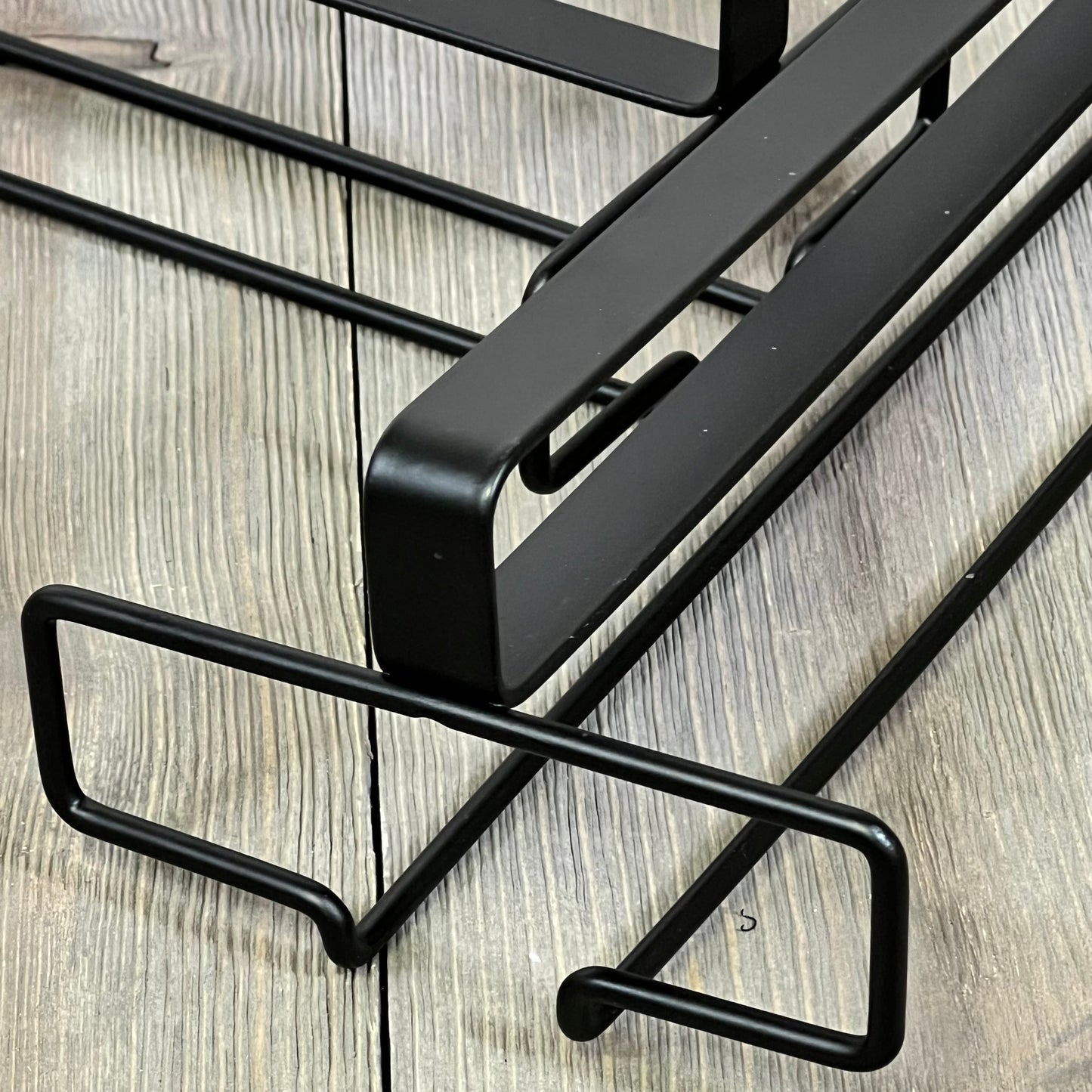 Black under-cabinet wine glass rack with sleek design for efficient kitchen storage. Durable and stylish stemware holder.