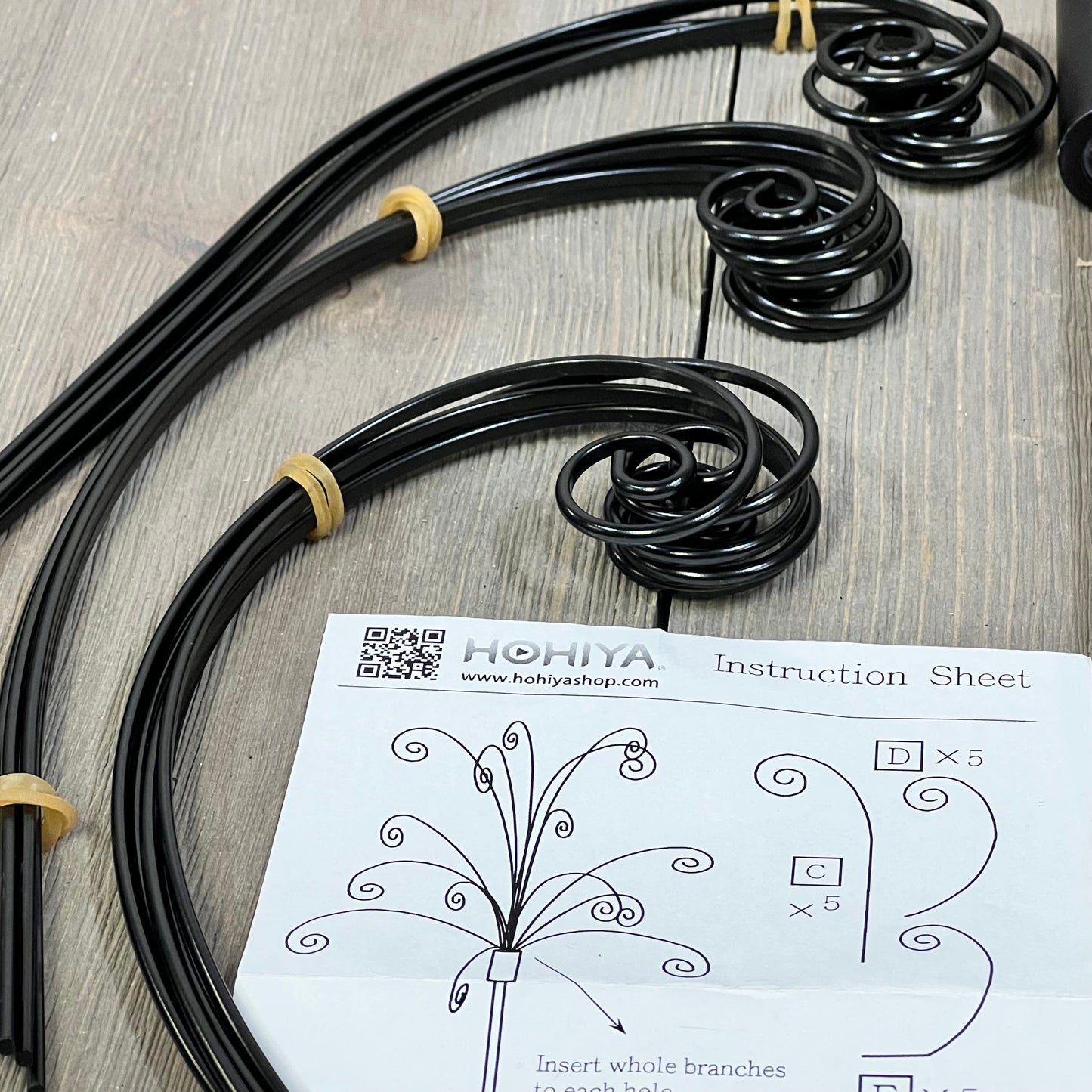 HOHIYA black metal ornament tree stand components with instruction sheet for assembly, ideal for Swarovski crystal displays.