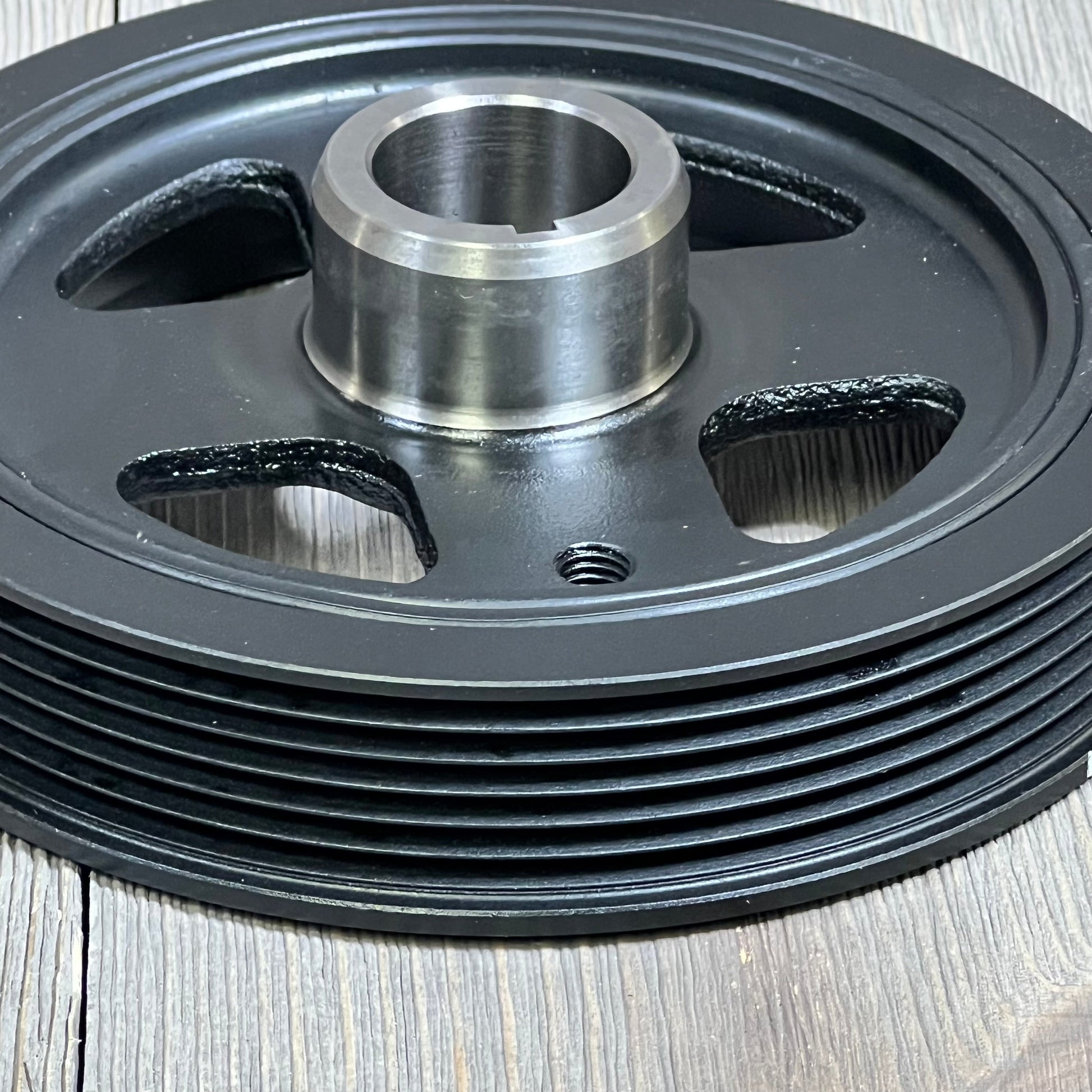 Close-up of AULINK 594-404 harmonic balancer crankshaft pulley for Lexus, Scion, Toyota, showing grooves and hub.