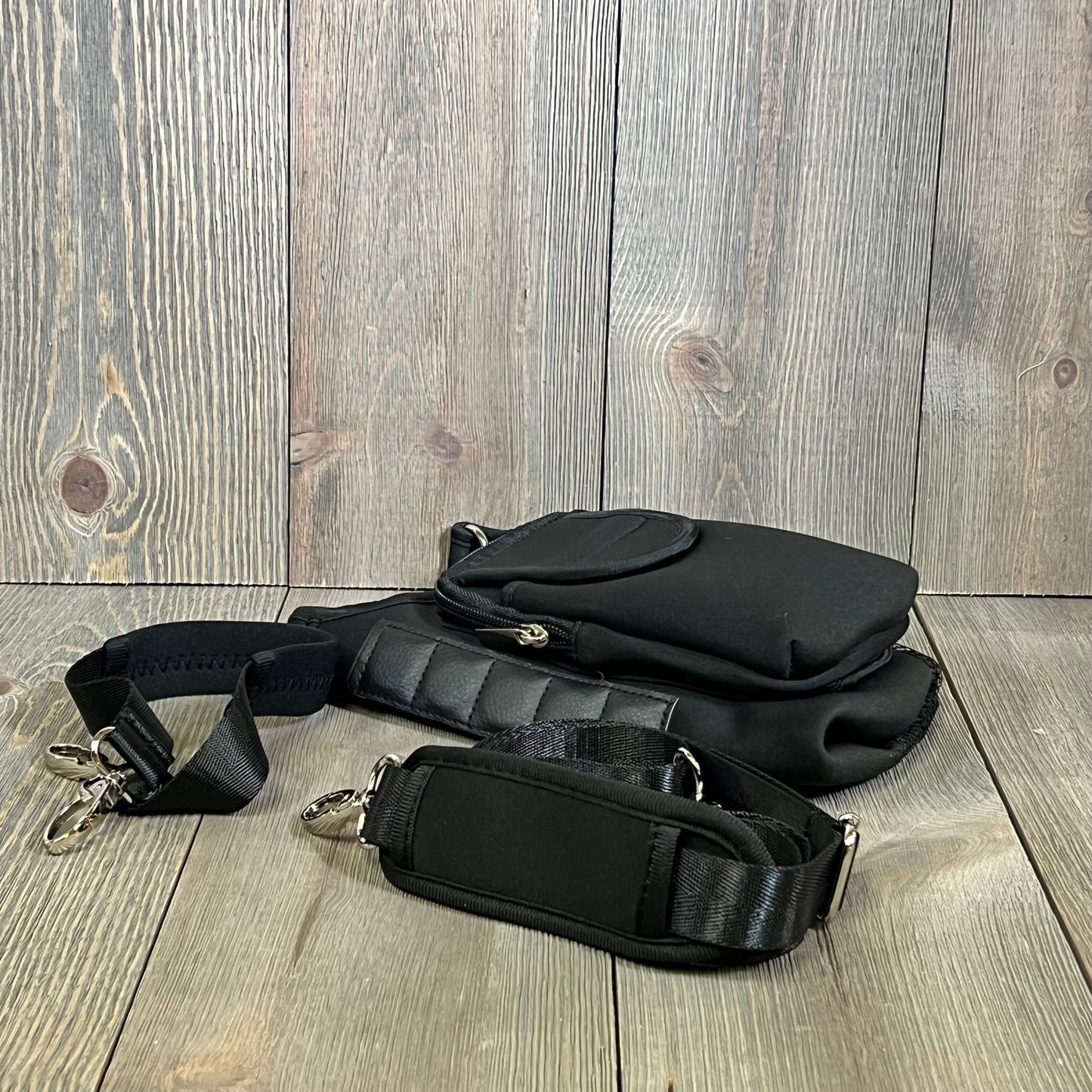 Black water bottle carrier bag with detachable shoulder strap and storage pouches, compatible with Stanley Cup.