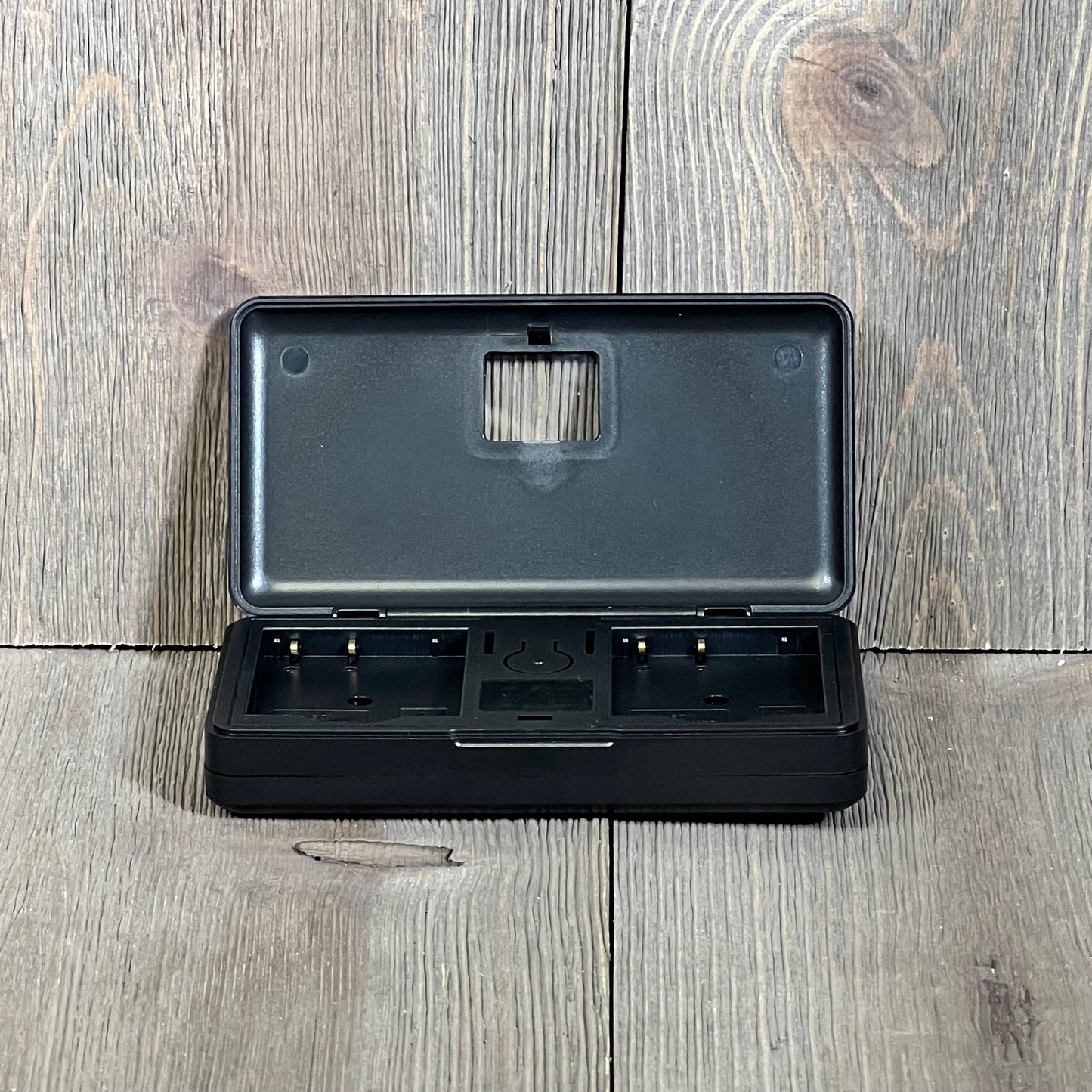 Dual slot charger for NP-BN1 batteries, ideal for Sony cameras like DSC-WX500 and TX100V, open on wooden background.