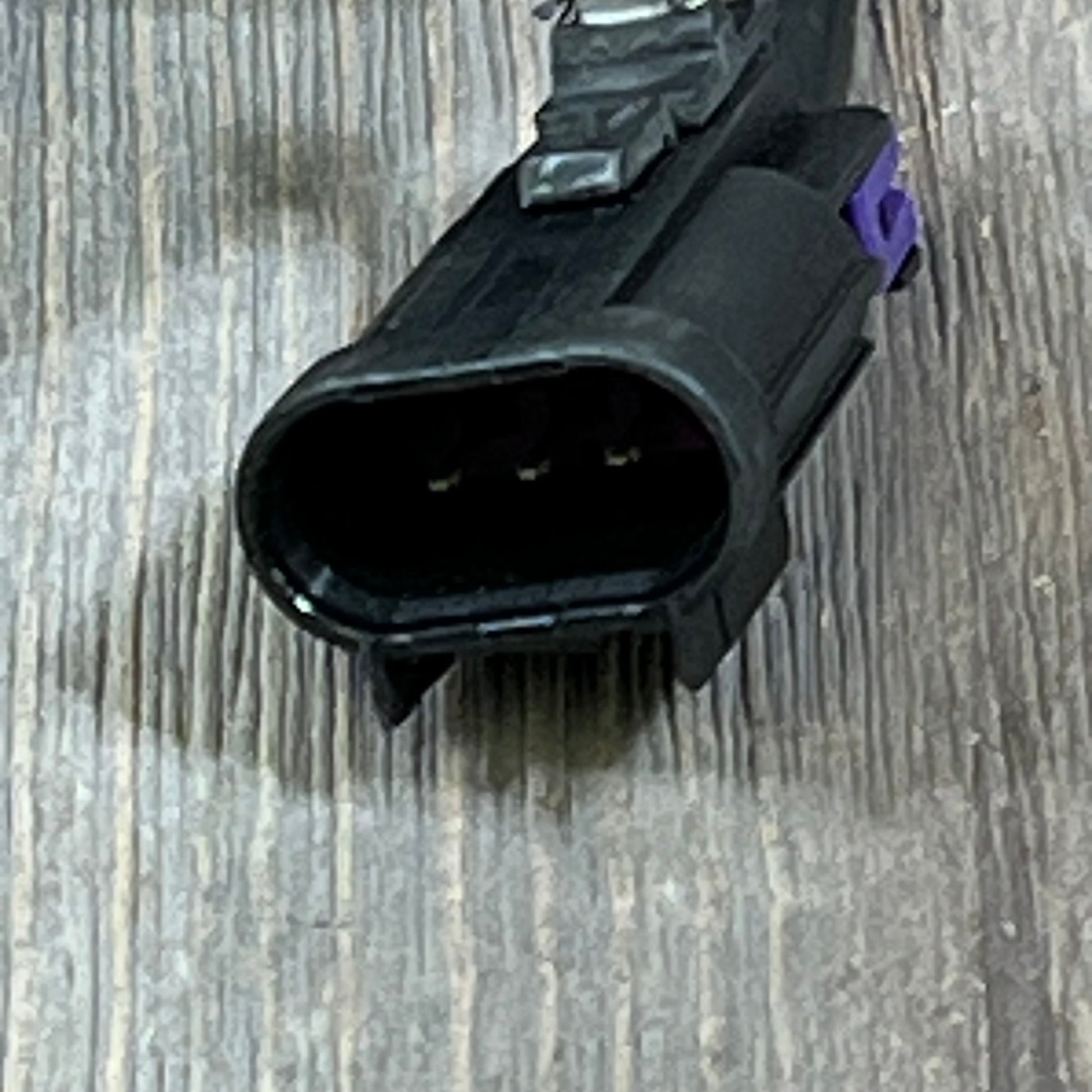 Black electrical connector for Chevy Tahoe hood latch 2015-2018, part GM1234115, shown on wooden surface.