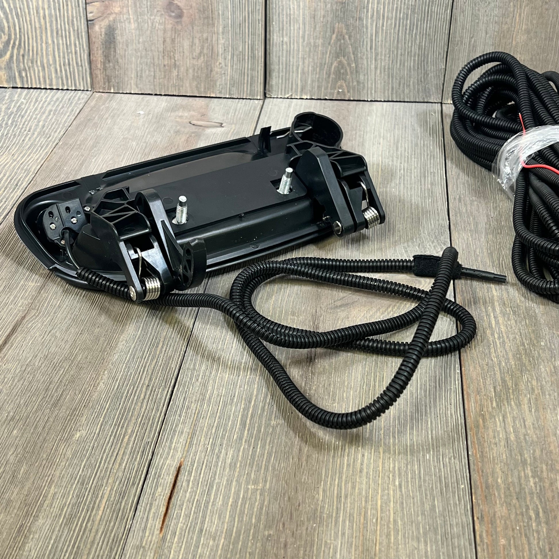 Ford F-150 backup camera tailgate handle with wiring, compatible with various Ford models, shown on wooden surface.