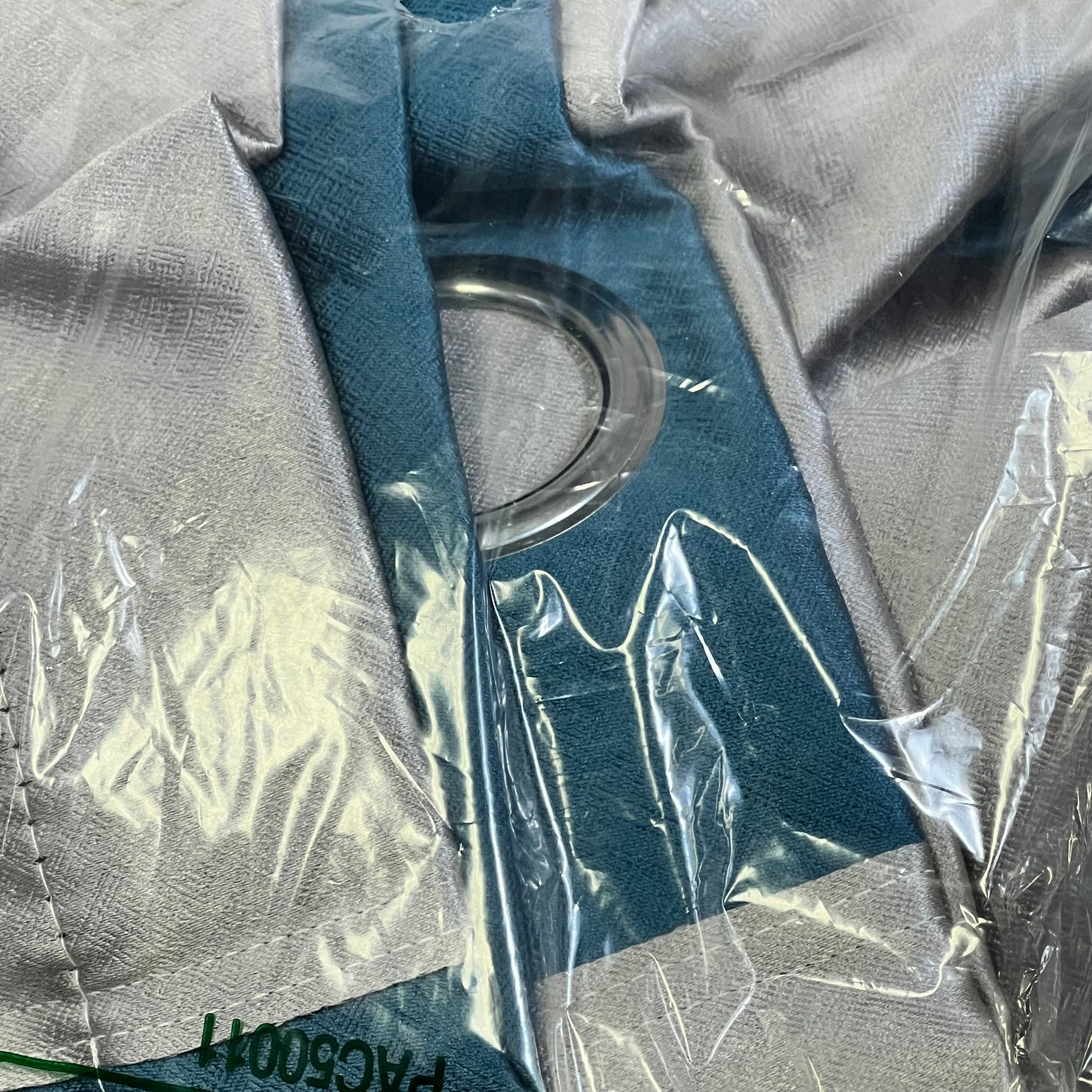 Blue and grey patchwork curtains in packaging, featuring thermal insulation and grommet design for living room decor.