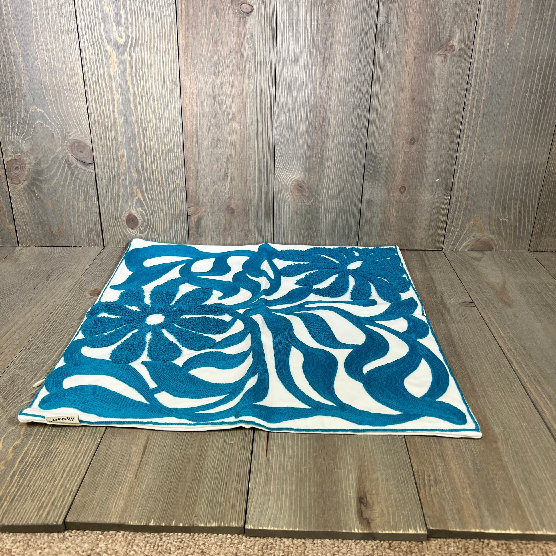 Teal blue throw pillow cover with boho floral embroidery, ideal for adding a chic touch to a couch or bed.