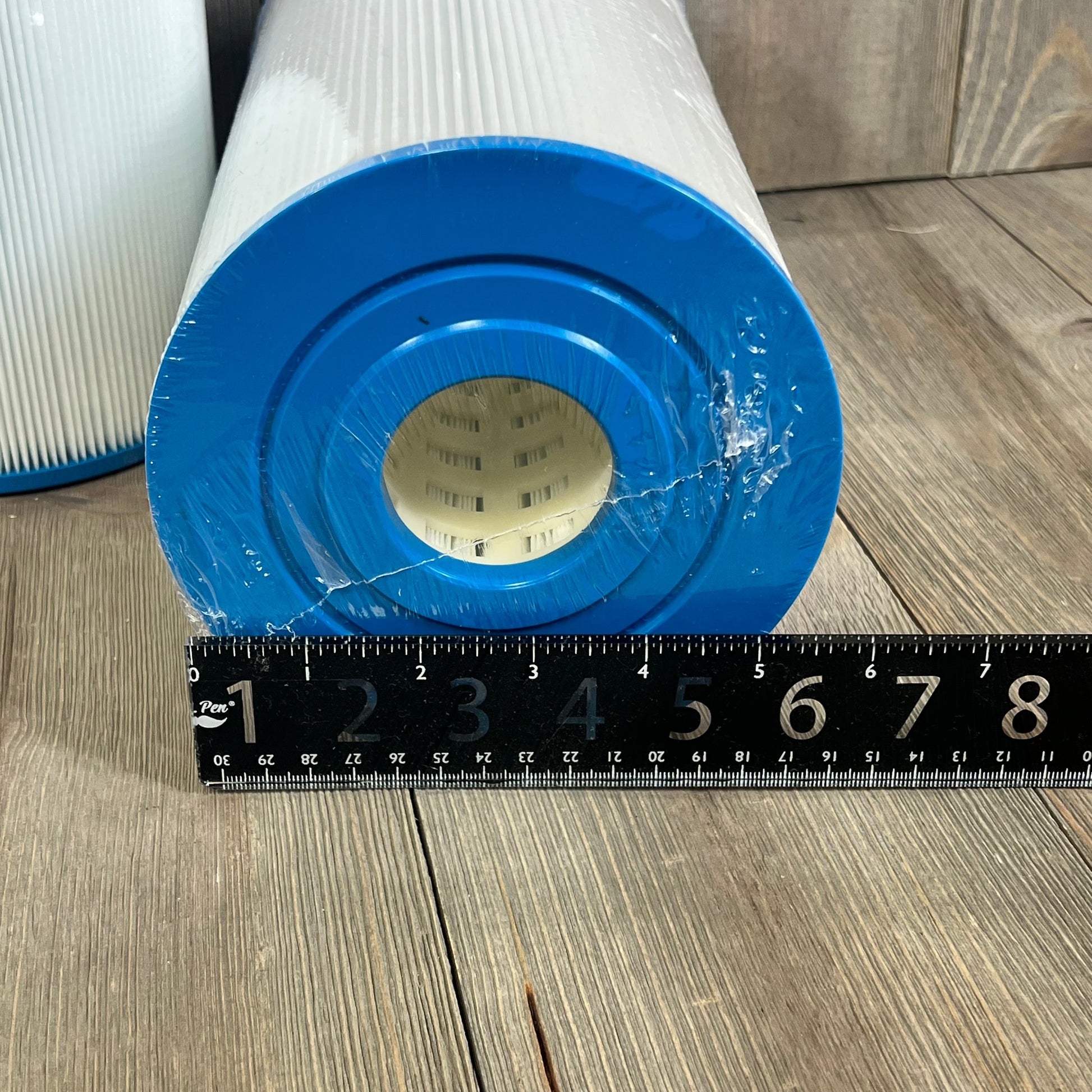 Blue end cap of Yoozell PWK30-EC Spa Filter Cartridge next to ruler, showcasing size for hot tubs.