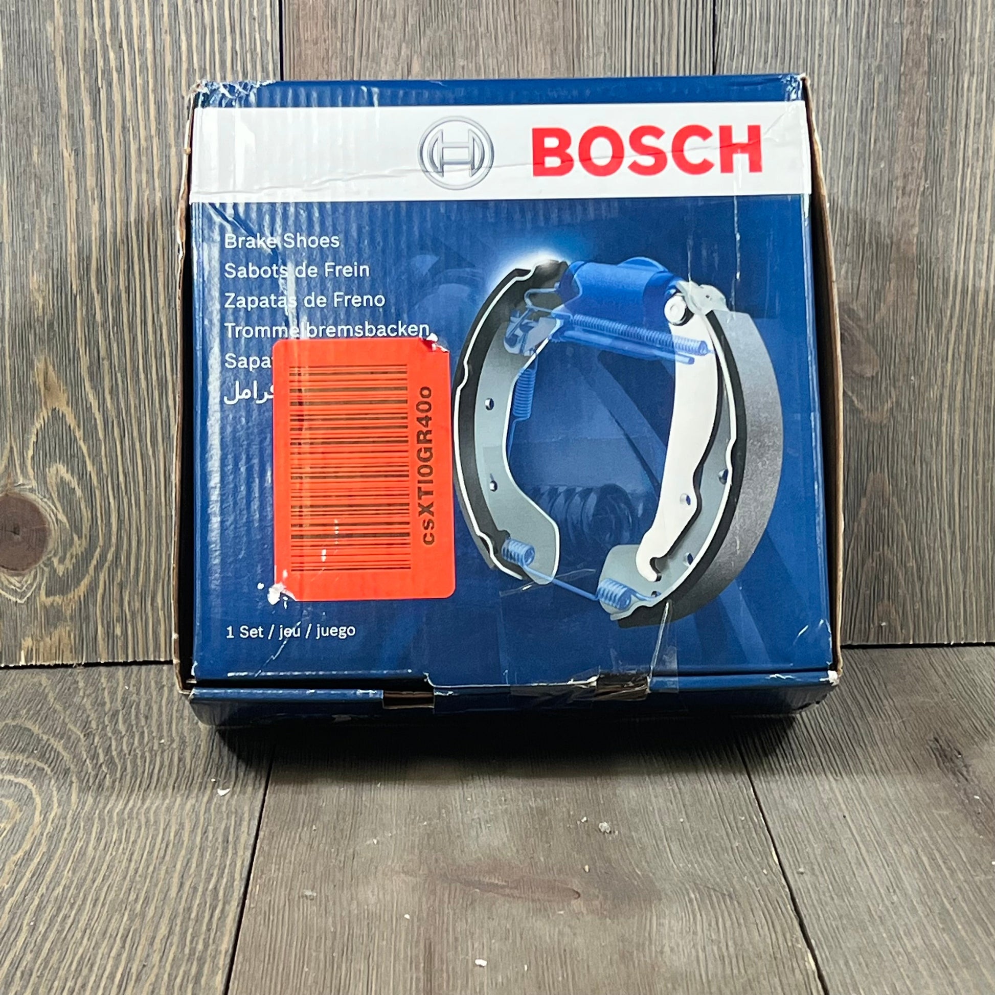 BOSCH BS886 Blue Parking Brake Shoe Set packaging for Chrysler, Dodge, Jeep, Mitsubishi models on wooden background.