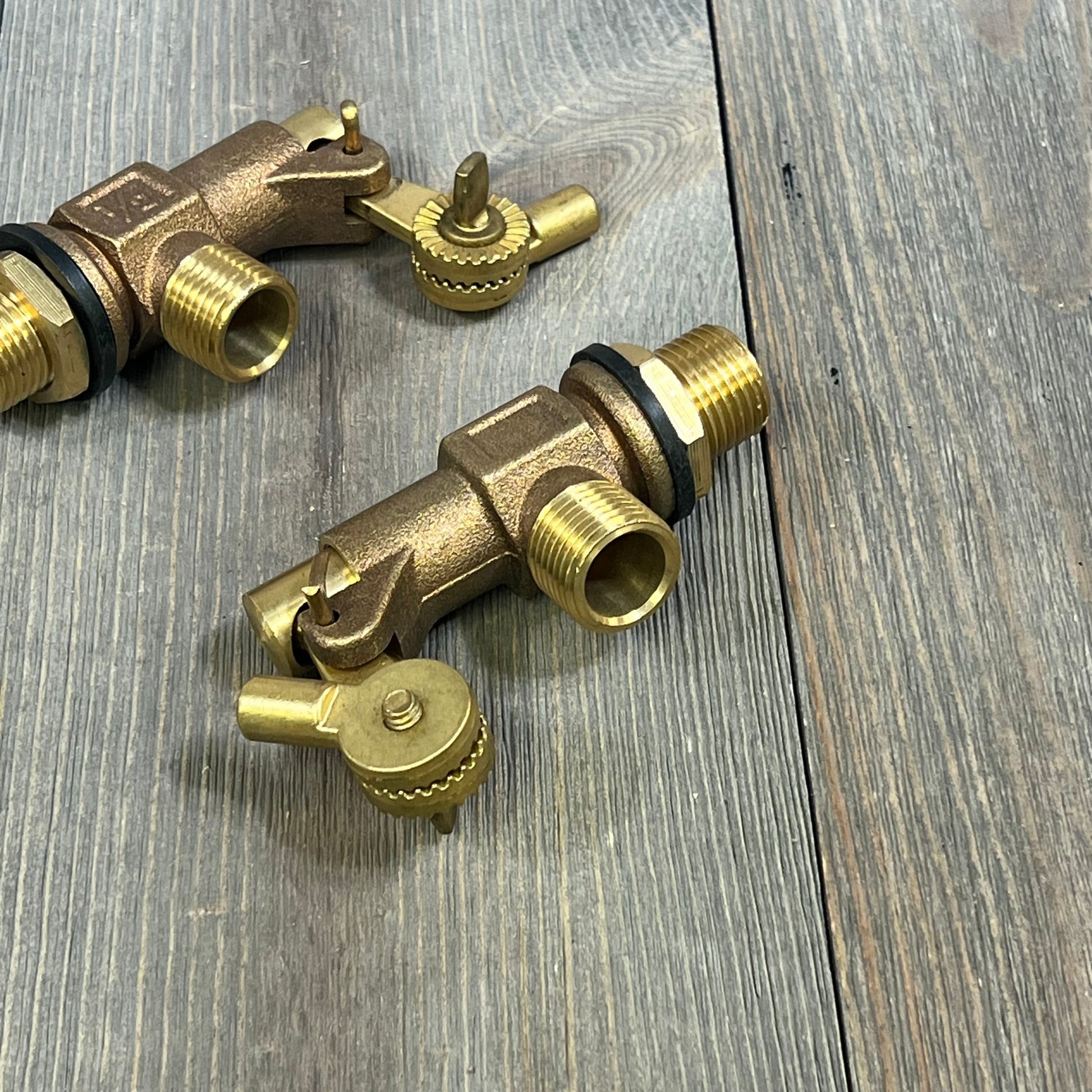 Bronze Blulu float valves with 1/2 inlet and male outlet for water storage tanks on wooden surface, durable design.