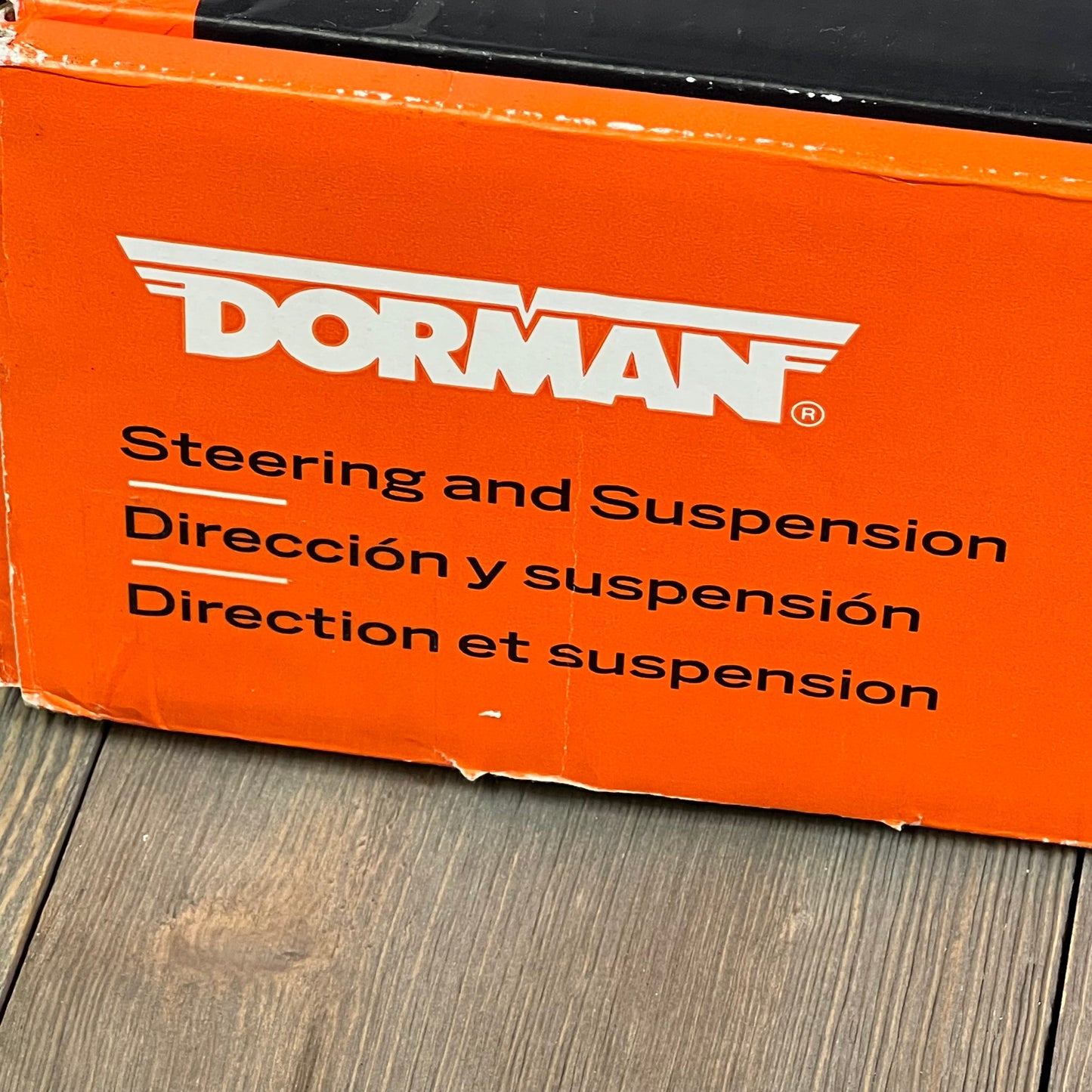Dorman suspension control arm packaging with multilingual steering instructions.